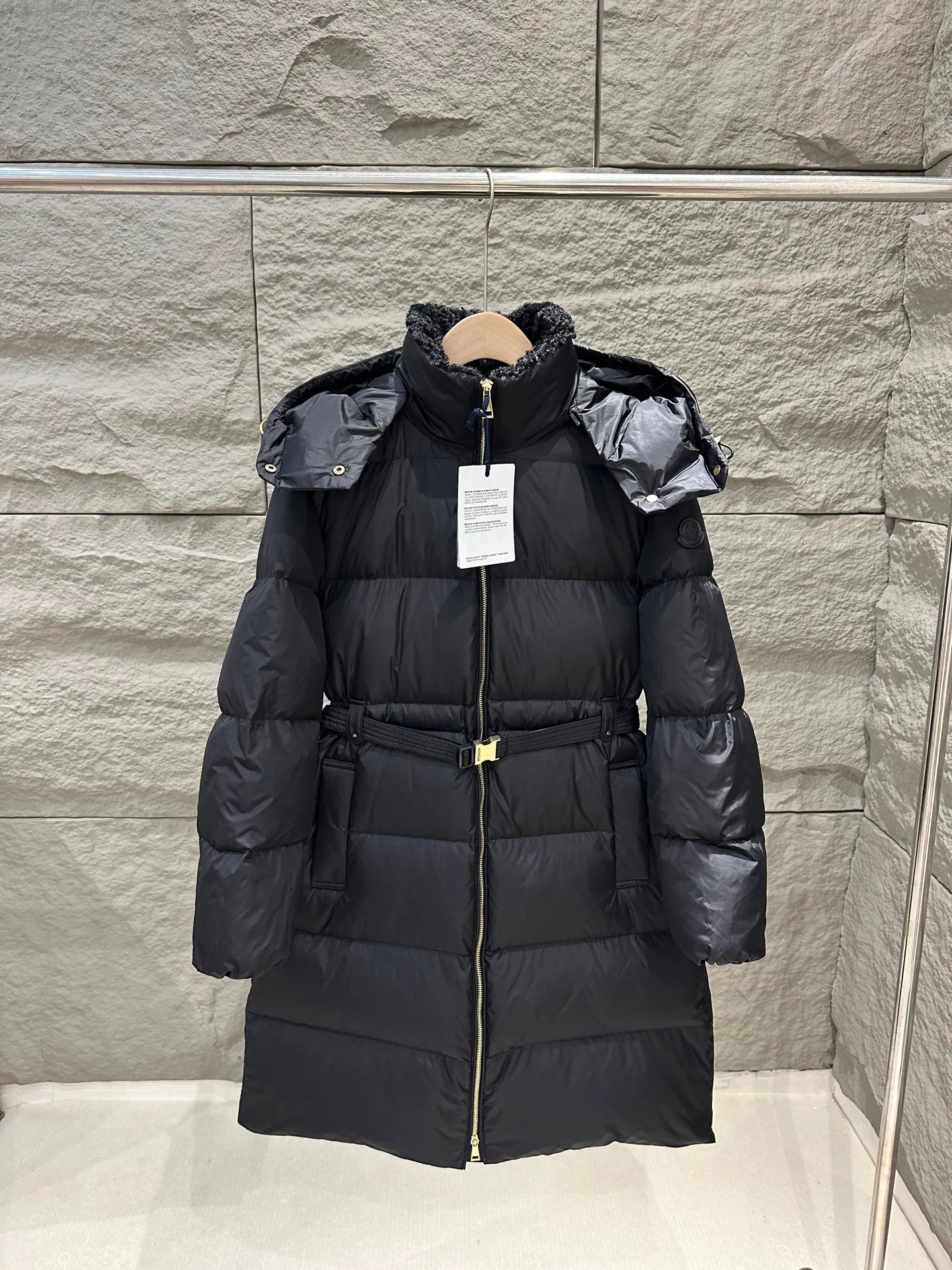 P1120 Moncler Briant Women's Hooded Long Waisted Down Jacket Jacket The Briant down jacket is designed to be both practical and comfortable to meet daily needs. Functional nylon fabric combined with a removable hood makes it easy to adapt to changing weather. This warm piece's wrap silhouette can be transformed from practical to sophisticated by adding a feminine touch with a detachable belt. The teddy velvet style collar design highlights the gentle style. Color: Black Size: 0/1/2/3