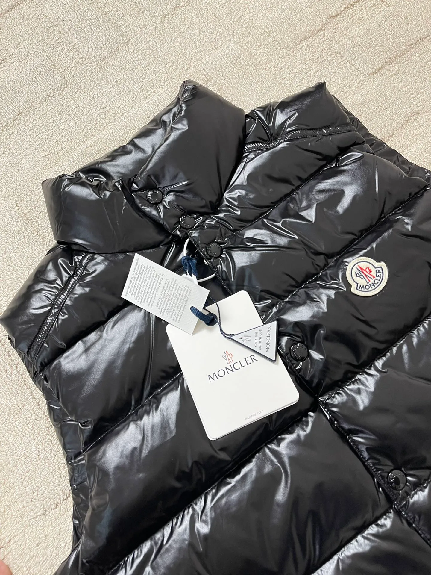 Tile details P820 Moncler Tibb Men's Tibb Vest Vest Down Jacket The Tibb men's vest is Moncler's classic item, inspired by the iconic archive silhouette of the 1980s. Made from nylon laqué fabric, it can be worn as an urban outerwear piece during the changing seasons, or layered over a jacket to complete a look in the colder months.  Fabric: 100% nylon; Lining: 100% nylon; Filling down content: 90% white duck down, 10% feather Filling capacity: 180-200g, Craftsmanship: Made of nylon laqué fabric, Nylon laque lining, down filling, zipper closure, collar with snap closure, zipper pocket, zipper internal pocket Size: 1 2 3 4 5 6 0330020