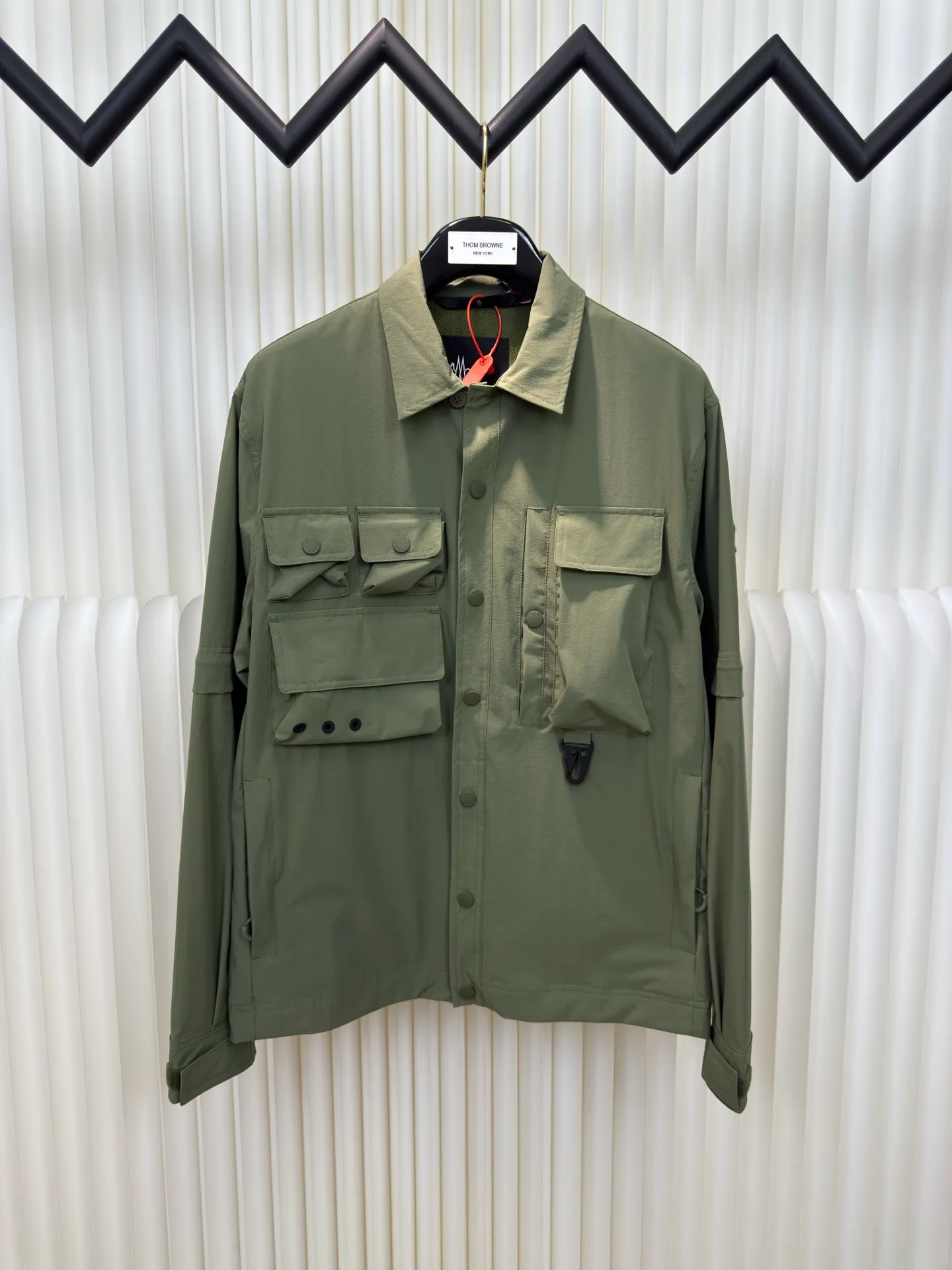 P640 Moncler Grenoble Functional Outdoor Jacket Custom-dyed double-stretch mercerized poplin Custom-dyed soft-mesh pongee Excellent texture Comfortable and close to the skin Dark green inspired by plant texture The color is taken from sage leaves soaked in morning dew Precision narrative of functional pocket system Balance of function and aesthetics The iconic Moncler logo appears on the sleeves, fully recognizable The triangular logo of the same color is hidden in the fabric texture like a mark in the undercurrent of the deep sea Extremely hidden and visible. The detachable sleeve design allows for diversified outfits. You can switch styles at will. Feel free and elegant. Show your dignity. Balance outdoor practicality and urban aesthetics. Lead the fashion. Adopt three-in-one process. Give priority to evenly coating the glue on the surface of the substrate that needs to be composited. Then dry and solidify. Then laminate the substrate with the adhesive film and the non-woven fabric. Then cool and solidify. Then composite the filter non-woven fabric. The workmanship is cumbersome and complex. Time-consuming and labor-intensive. Embossed composite technology Through computer scanning, ensure that the imprint size and shape are consistent with the original. Then use special glue as an adhesive to combine and then solidify to achieve complete dryness and the best bonding effect. Use CNC laser burning and cutting based on the high-energy characteristics of the laser. Precisely control the movement path of the laser beam with a laser generator to achieve precise cutting of the shape of the piece. Template machine bag opening. The preset template guides the position, shape and size of the bag opening. The accuracy ensures the quality of the bag opening effect. Uses infrared special machine to fasten the position more accurately. Strong and sturdy, loose fit, detachable sleeve splicing, style can be switched at will Size: 1 2 3 4