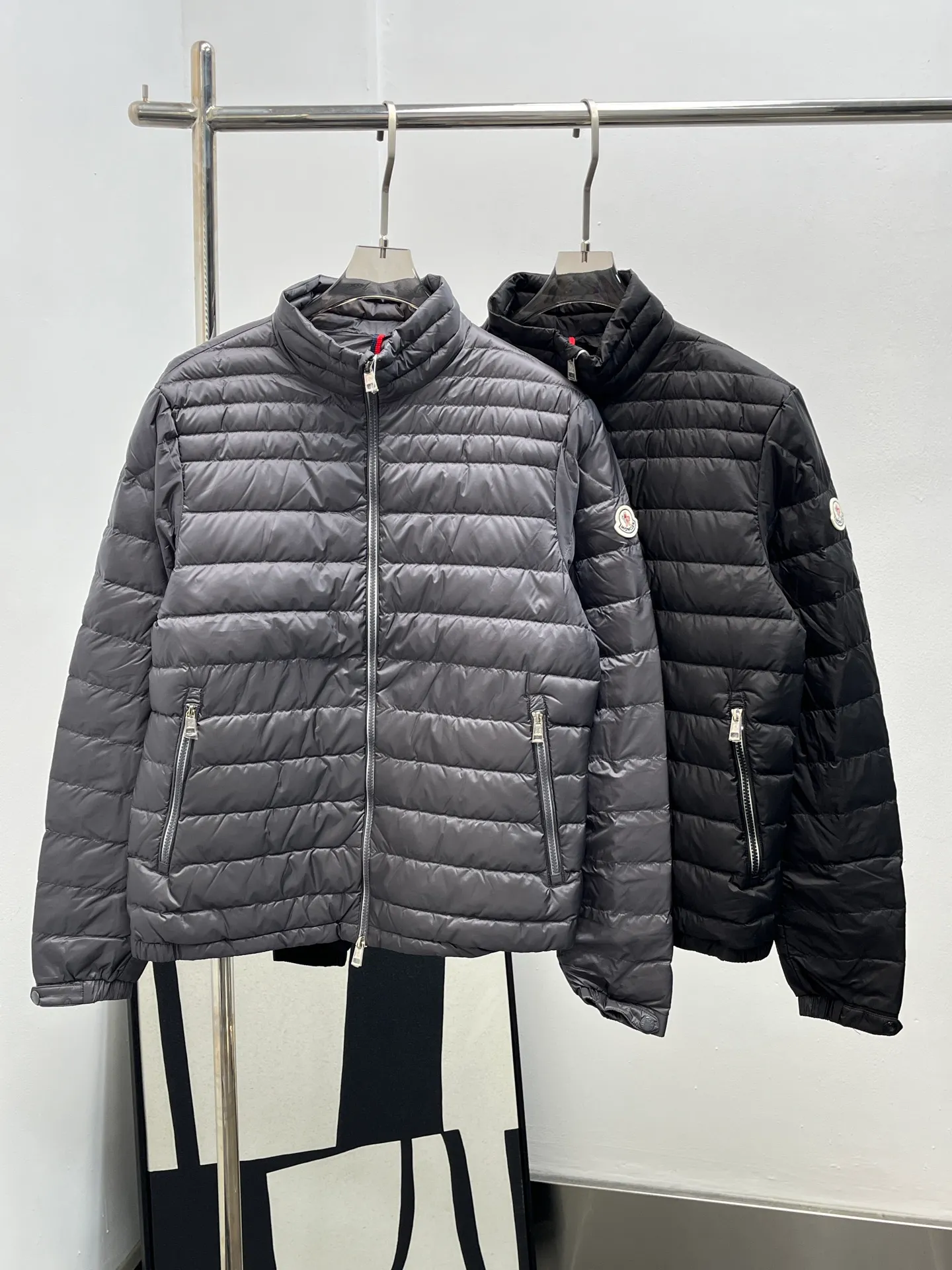 P920 25Moncler *Arnique men's short down is light and thin. Arnique short down is light and warm and made of longue saison fabric. This functional nylon fabric provides warmth without being bulky. This style is finished with quilting in varying sized squares, which helps give it a lightweight texture. The classic fit design can be easily paired with urban casual wear or as sports wear for outdoor activities. Color: black gray