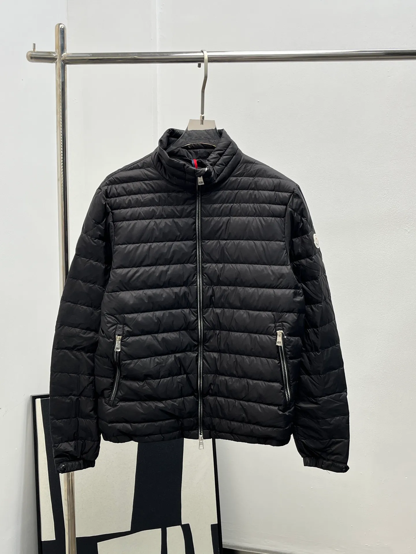 P920 25Moncler *Arnique men's short down is light and thin. Arnique short down is light and warm and made of longue saison fabric. This functional nylon fabric provides warmth without being bulky. This style is finished with quilting in varying sized squares, which helps give it a lightweight texture. The classic fit design can be easily paired with urban casual wear or as sports wear for outdoor activities. Color: black gray