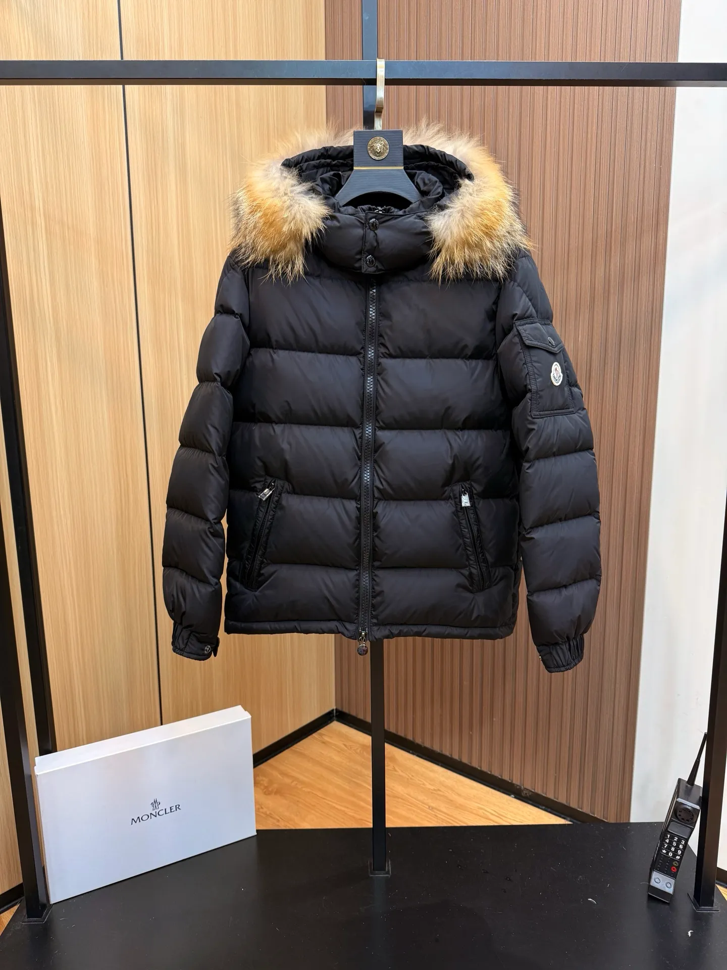 P1000 Moncler Mayaf short men's down jacket jacket. The hood is removable. The fur collar is removable. Based on Maya, a removable fur collar is added. The Mayaf men's hooded down jacket is made of functional nylon fabric, and the hood is equipped with removable synthetic material trim.  The Mayaf short down jacket is a reinterpretation of the classic Moncler Maya style in an instantly recognizable silhouette, with a removable hood and adjustable hem. Made from functional fabric with removable synthetic trim on the hood. The sleeves are embellished with classic patch pockets, reflecting the brand's signature style. Details •Made from functional fabric •Technical fabric lining •Down-filled •Push-stud collar •Detachable hood with removable synthetic trim •Zip closure •Zip pockets •Patch pockets with press-stud •Adjustable elastic cuffs •Adjustable drawstring hem