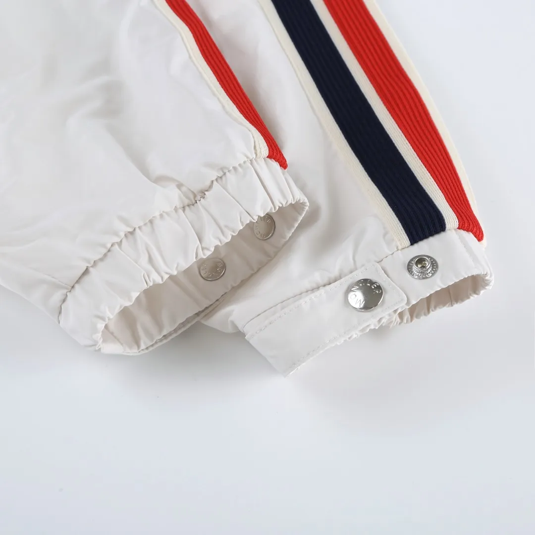 P540 MONCLER web-trimmed lightweight jacket Fabric selection: 100% polyester fiber is used to create a tough protective outer layer. It is known for its excellent tear resistance and wear resistance. It can quickly return to flatness during wearing and maintain the crisp and stylish appearance of the clothing for a long time. At the same time, it is not easy to deform after being washed for a long time.   Features: Two different colored decorative strips added to the center part of the sleeves. This design element can not only add visual highlights to clothing, making it more fashionable and unique. Craftsmanship: The webbing is precisely positioned along the cuffs to the seam of the collar and hat to ensure symmetry and overall smoothness. Before actual sewing, use very fine basting stitches for pre-fixing. This step is crucial to prevent the webbing from slipping, twisting, or wrinkling during sewing and ensuring that the final stitch is straight and perfect.  Accessories: 1:1 customized zipper puller, 1:1 customized buttons with logo, 1:1 customized hood drawstring elastic buckle SIZE: 1 2 3 4