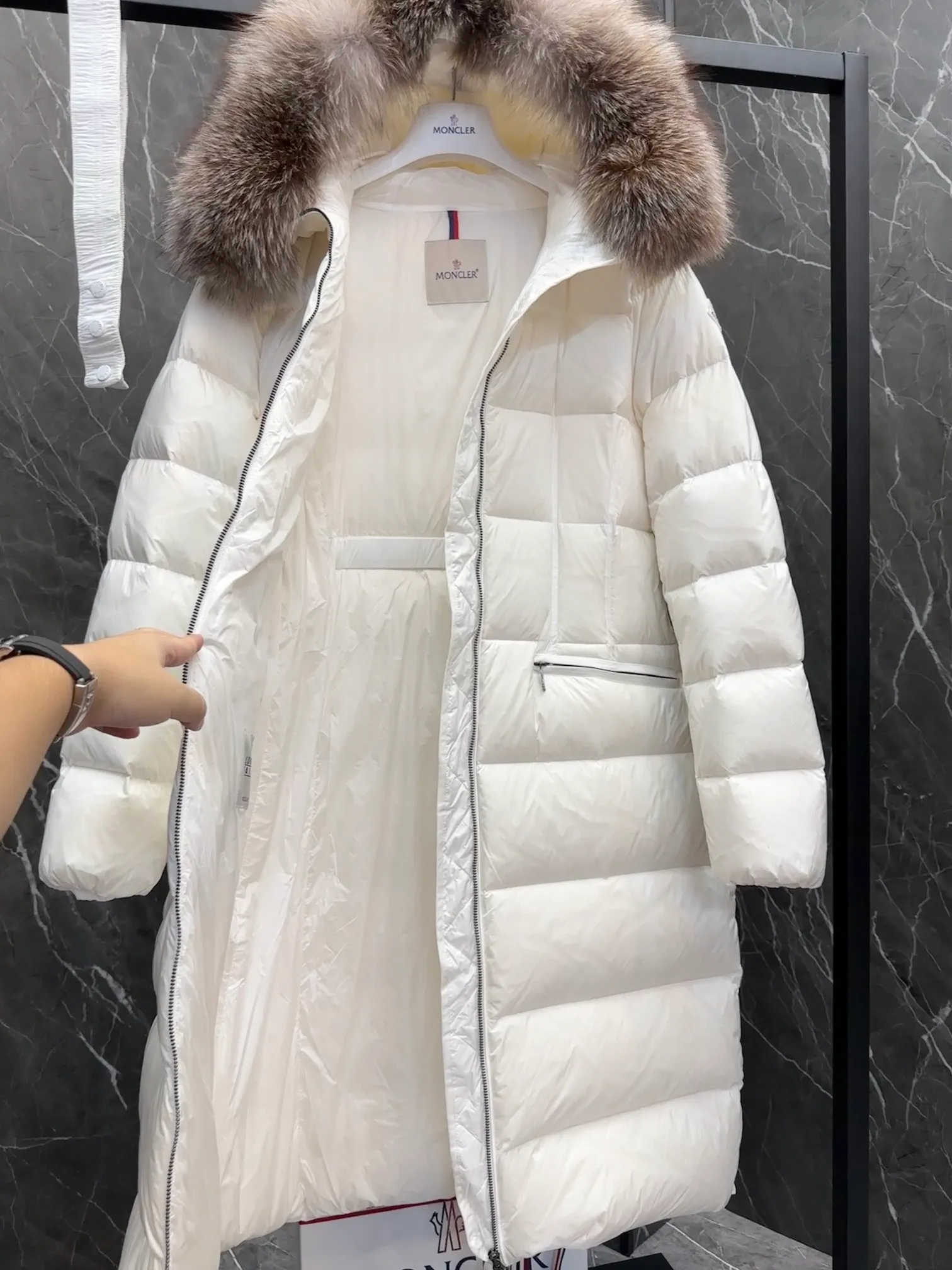 P1020 Moncler Boedic long down jacket for women. (Classic fox fur collar) adopts a whole fox fur collar imported from Finland. The Boedic long down jacket combines exquisite materials and attention to details. The timeless and elegant fashion design can provide you with a warm and caring wearing experience.  Boedic's long down jacket features a waist-cinching belt to accentuate its feminine silhouette for a stylish winter look. The cozy hood has rich fleece trim and is easily removable to suit your mood and weather conditions. Details •Made from lounge saison fabric •Longue saison lining •Filled with down •Hood with removable fox fur collar trim •Two-way zip closure •Elastic waistband with snap button closure •Zip pockets with grosgrain detail •Elastic cuffs Size : 1-4