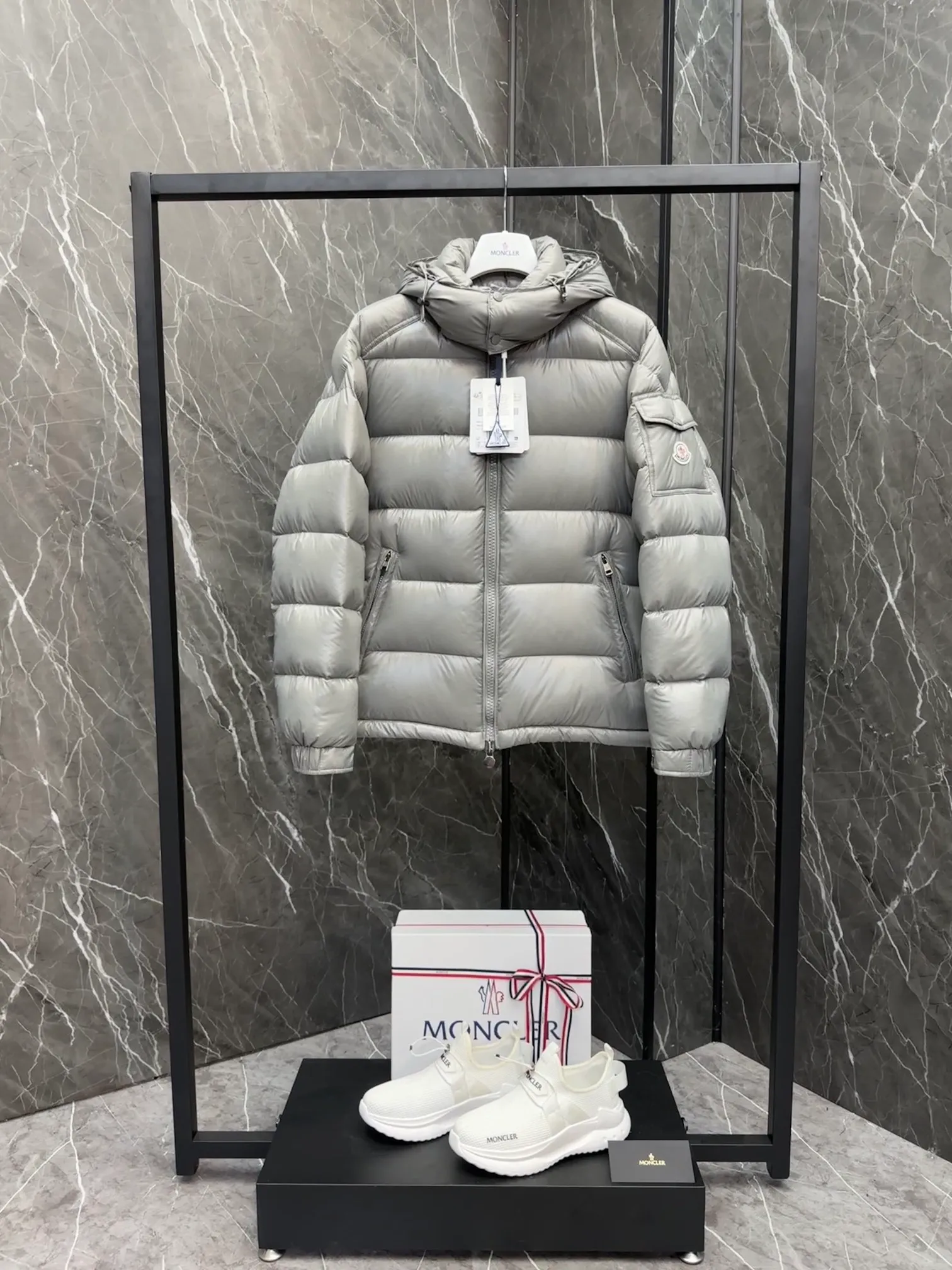 P700 Premium Down ⬆️Moncler Maya classic short down jacket. ⚠️Limited to gray, the only matching color on the market, filled with premium goose down. Try this color on, I guarantee you won’t be able to take it off, it’s too high-end. The Moncler Maya short down jacket is a classic Moncler item, and its style is highly recognizable. Made of lacquered nylon and available in a variety of colors, it's a stylish piece for casual commuting.  The Moncler Maya men's down jacket in shiny patent nylon with signature rectangular quilting is the epitome of Moncler style. A classic cropped design that transcends seasons and styles, it features a statement silhouette, removable hood and adjustable hem. The cuffs are embellished with classic patch pockets, showcasing the brand's signature style. Details • Made of patented nylon • Lacquered nylon lining • Filled with down, rectangular quilting • Detachable hood with snap buttons and drawstring adjustment • Two-way zipper fly • External and internal zippered pockets • Adjustable elastic cuffs with press studs • Drawstring on hood • Flap patch pockets on sleeves • Moncler felt logo on sleeves Size: 1-8 Premium Gray Couple Style.