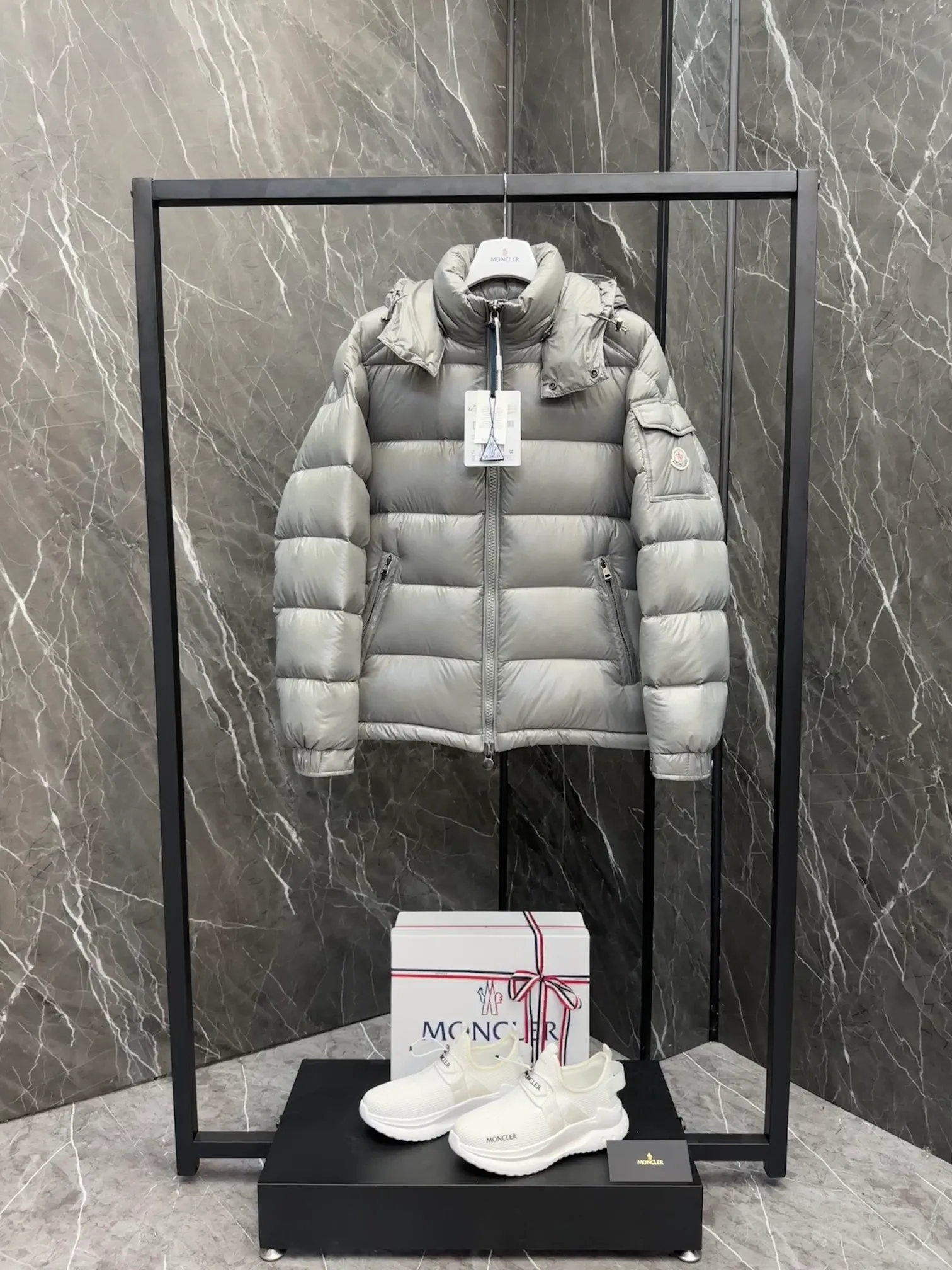 P700 Premium Down ⬆️Moncler Maya classic short down jacket. ⚠️Limited to gray, the only matching color on the market, filled with premium goose down. Try this color on, I guarantee you won’t be able to take it off, it’s too high-end. The Moncler Maya short down jacket is a classic Moncler item, and its style is highly recognizable. Made of lacquered nylon and available in a variety of colors, it's a stylish piece for casual commuting.  The Moncler Maya men's down jacket in shiny patent nylon with signature rectangular quilting is the epitome of Moncler style. A classic cropped design that transcends seasons and styles, it features a statement silhouette, removable hood and adjustable hem. The cuffs are embellished with classic patch pockets, showcasing the brand's signature style. Details • Made of patented nylon • Lacquered nylon lining • Filled with down, rectangular quilting • Detachable hood with snap buttons and drawstring adjustment • Two-way zipper fly • External and internal zippered pockets • Adjustable elastic cuffs with press studs • Drawstring on hood • Flap patch pockets on sleeves • Moncler felt logo on sleeves Size: 1-8 Premium Gray Couple Style.