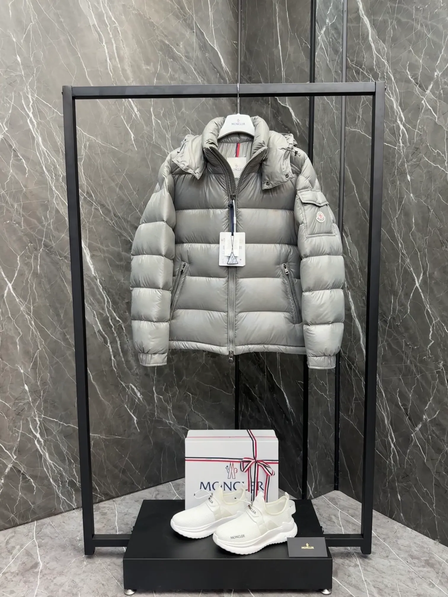 P700 Premium Down ⬆️Moncler Maya classic short down jacket. ⚠️Limited to gray, the only matching color on the market, filled with premium goose down. Try this color on, I guarantee you won’t be able to take it off, it’s too high-end. The Moncler Maya short down jacket is a classic Moncler item, and its style is highly recognizable. Made of lacquered nylon and available in a variety of colors, it's a stylish piece for casual commuting.  The Moncler Maya men's down jacket in shiny patent nylon with signature rectangular quilting is the epitome of Moncler style. A classic cropped design that transcends seasons and styles, it features a statement silhouette, removable hood and adjustable hem. The cuffs are embellished with classic patch pockets, showcasing the brand's signature style. Details • Made of patented nylon • Lacquered nylon lining • Filled with down, rectangular quilting • Detachable hood with snap buttons and drawstring adjustment • Two-way zipper fly • External and internal zippered pockets • Adjustable elastic cuffs with press studs • Drawstring on hood • Flap patch pockets on sleeves • Moncler felt logo on sleeves Size: 1-8 Premium Gray Couple Style.
