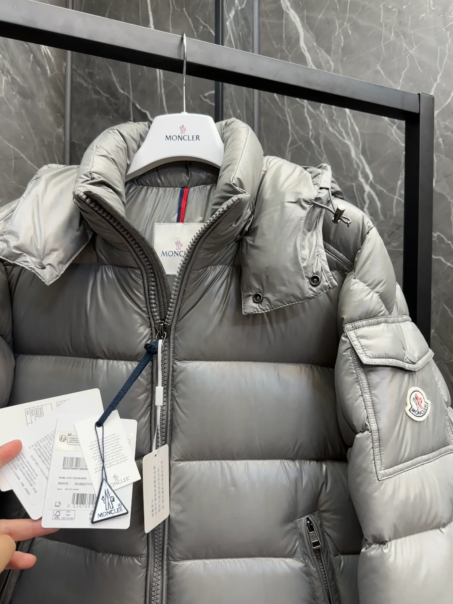 P700 Premium Down ⬆️Moncler Maya classic short down jacket. ⚠️Limited to gray, the only matching color on the market, filled with premium goose down. Try this color on, I guarantee you won’t be able to take it off, it’s too high-end. The Moncler Maya short down jacket is a classic Moncler item, and its style is highly recognizable. Made of lacquered nylon and available in a variety of colors, it's a stylish piece for casual commuting.  The Moncler Maya men's down jacket in shiny patent nylon with signature rectangular quilting is the epitome of Moncler style. A classic cropped design that transcends seasons and styles, it features a statement silhouette, removable hood and adjustable hem. The cuffs are embellished with classic patch pockets, showcasing the brand's signature style. Details • Made of patented nylon • Lacquered nylon lining • Filled with down, rectangular quilting • Detachable hood with snap buttons and drawstring adjustment • Two-way zipper fly • External and internal zippered pockets • Adjustable elastic cuffs with press studs • Drawstring on hood • Flap patch pockets on sleeves • Moncler felt logo on sleeves Size: 1-8 Premium Gray Couple Style.