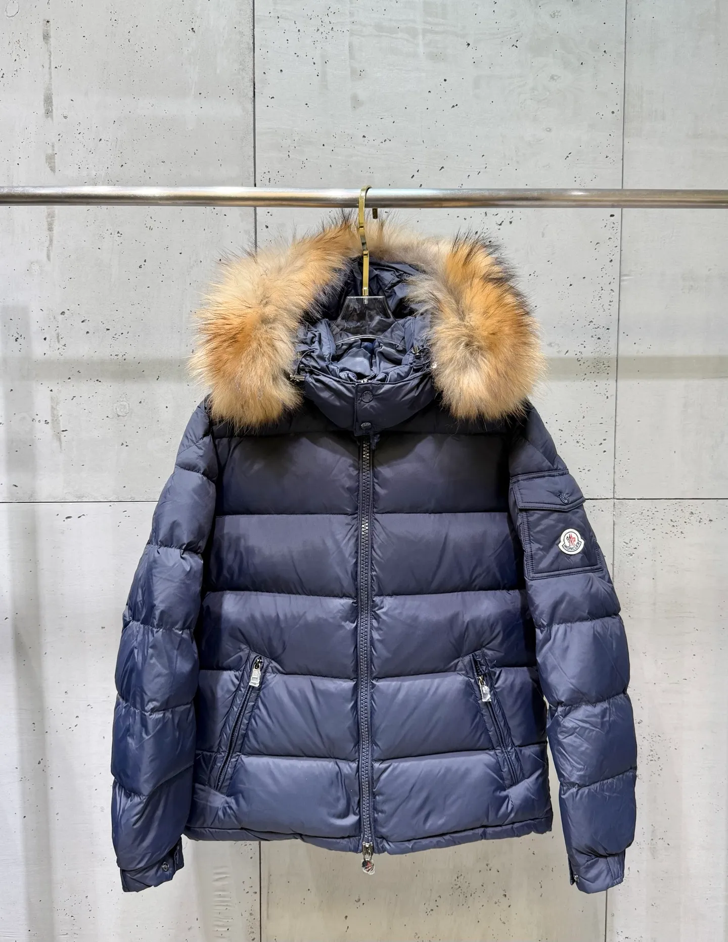 P1040 Men's Moncler Mayaf short men's down jacket. The hood is removable and the fur collar is removable. Based on Maya, a removable fur collar is added. The Mayaf men's hooded down jacket is made of functional nylon fabric, and the hood is equipped with removable synthetic material trim. The Mayaf short down jacket is a reinterpretation of the classic Moncler Maya style in an instantly recognizable silhouette, with a removable hood and adjustable hem. Made from functional fabric with removable synthetic trim on the hood. The sleeves are embellished with classic patch pockets, reflecting the brand's signature style. Details •Made from functional fabric •Technical fabric lining •Down-filled •Snap-stud collar •Detachable hood with removable synthetic trim •Zip closure •Zip pockets •Patch pockets with press-stud •Adjustable elastic cuffs •Adjustable drawstring hem Size : 1-5