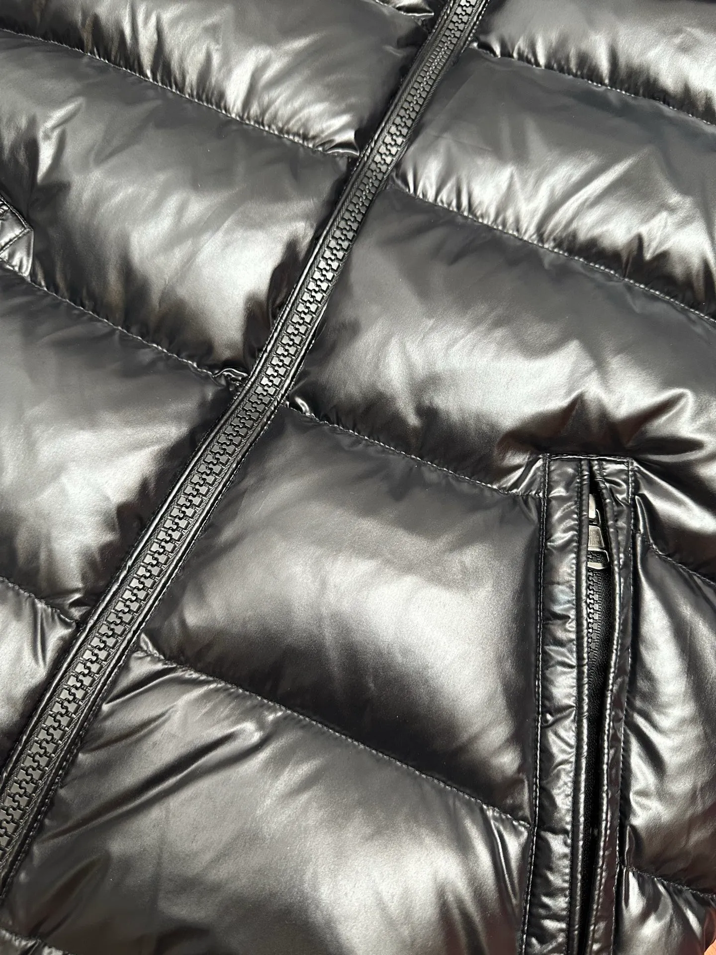 P1040 Premium down ⬆️ Moncler Maya short men's down jacket jacket. Classic Maya (latest purchase counter 2025) The latest classic fabrics are on sale at the counter. ⚠️Maya is a classic series at the counter. Every year there are minor changes. Change the soup without changing the medicine. Not to save development costs, only the latest and best. The Moncler Maya short down jacket is a classic Moncler item, with a highly recognizable style. Made of lacquered nylon and available in many colors, it is a fashionable item for casual commuting and a popular product.  The Moncler Maya men's down jacket in shiny patent nylon with signature rectangular quilting is the epitome of Moncler style. A classic cropped design that transcends seasons and styles, it features a statement silhouette, removable hood and adjustable hem. The cuffs are embellished with classic patch pockets, showcasing the brand's signature style. Details •Made from patented nylon •Painted nylon lining •Down-filled, rectangular quilting •Detachable hood with snap fastening and drawstring adjustment •Two-way zip fly •Exterior and internal zippered pockets •Adjustable elastic cuffs with press-stud •Drawstring at hood •Flap patch pockets at sleeves •Moncler felt logo on sleeves Exclusive quality, hanging at home, five-layer anti-counterfeiting verification, NFC armband chip identification ➕NFC label washing chip identification ➕Elevator scan code verification ➕Washing label scan code verification ➕tag electronic anti-counterfeiting verification❗️❗️❗️ Color: Black Size: 1-6. Couple style