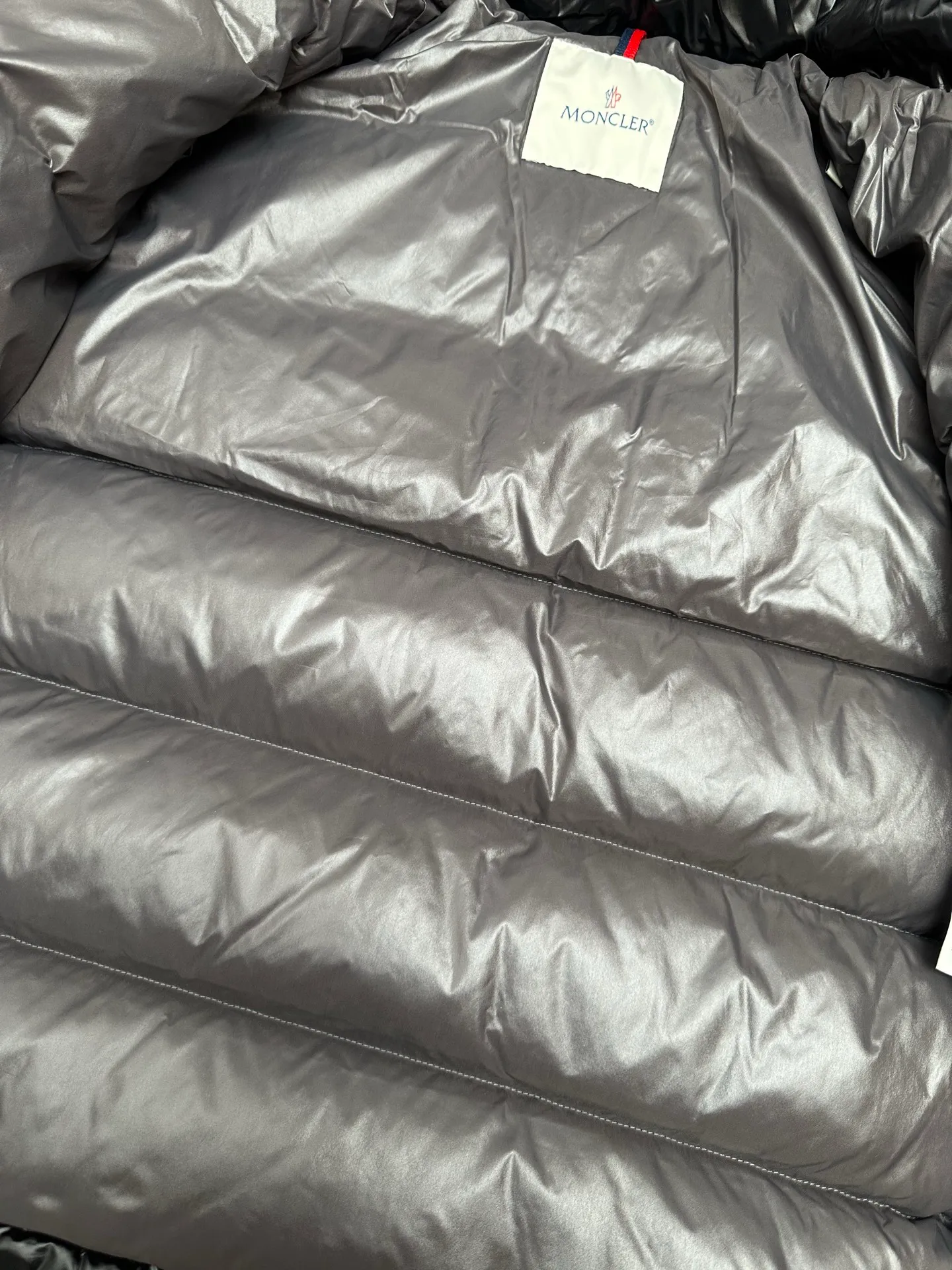 P1040 Premium down ⬆️ Moncler Maya short men's down jacket jacket. Classic Maya (latest purchase counter 2025) The latest classic fabrics are on sale at the counter. ⚠️Maya is a classic series at the counter. Every year there are minor changes. Change the soup without changing the medicine. Not to save development costs, only the latest and best. The Moncler Maya short down jacket is a classic Moncler item, with a highly recognizable style. Made of lacquered nylon and available in many colors, it is a fashionable item for casual commuting and a popular product.  The Moncler Maya men's down jacket in shiny patent nylon with signature rectangular quilting is the epitome of Moncler style. A classic cropped design that transcends seasons and styles, it features a statement silhouette, removable hood and adjustable hem. The cuffs are embellished with classic patch pockets, showcasing the brand's signature style. Details •Made from patented nylon •Painted nylon lining •Down-filled, rectangular quilting •Detachable hood with snap fastening and drawstring adjustment •Two-way zip fly •Exterior and internal zippered pockets •Adjustable elastic cuffs with press-stud •Drawstring at hood •Flap patch pockets at sleeves •Moncler felt logo on sleeves Exclusive quality, hanging at home, five-layer anti-counterfeiting verification, NFC armband chip identification ➕NFC label washing chip identification ➕Elevator scan code verification ➕Washing label scan code verification ➕tag electronic anti-counterfeiting verification❗️❗️❗️ Color: Black Size: 1-6. Couple style