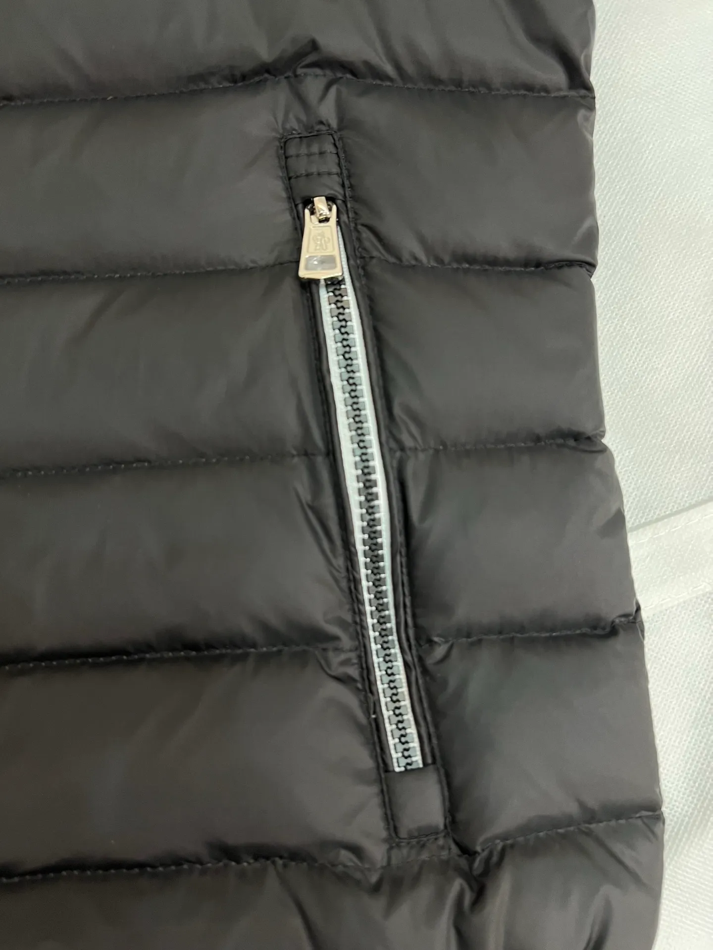 The P780 Arnique hooded down jacket with polyester outer fabric is Moncler's classic men's design.