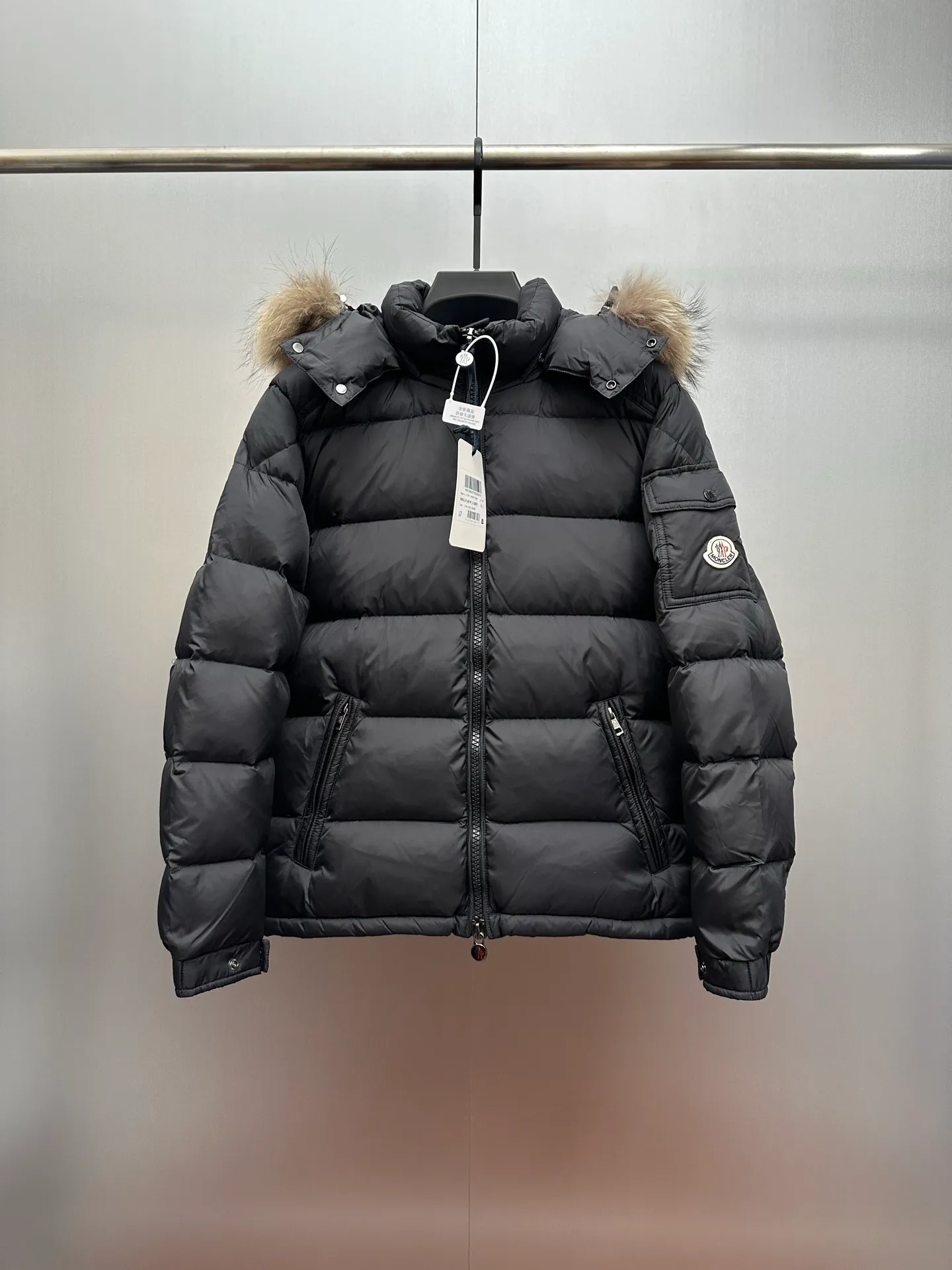 P1160 New down jacket⬆️Moncler Mayaf short men's down jacket jacket. The hood is removable and the fur collar is removable. Based on Maya, a removable fur collar is added. The Mayaf men's hooded down jacket is made of functional nylon fabric, and the hood is equipped with removable synthetic material trim.  The Mayaf short down jacket is a reinterpretation of the classic Moncler Maya style in an instantly recognizable silhouette, with a removable hood and adjustable hem. Made from functional fabric with removable synthetic trim on the hood. The sleeves are embellished with classic patch pockets, reflecting the brand's signature style. Details • Made from functional fabric • Lined with functional fabric • Filled with down • Press-stud collar • Detachable hood with removable synthetic trim • Zip closure • Zippered pockets • Patch pockets with press-stud • Adjustable elastic cuffs • Adjustable drawstring hem Color: Black/Navy Blue Size : 1-6