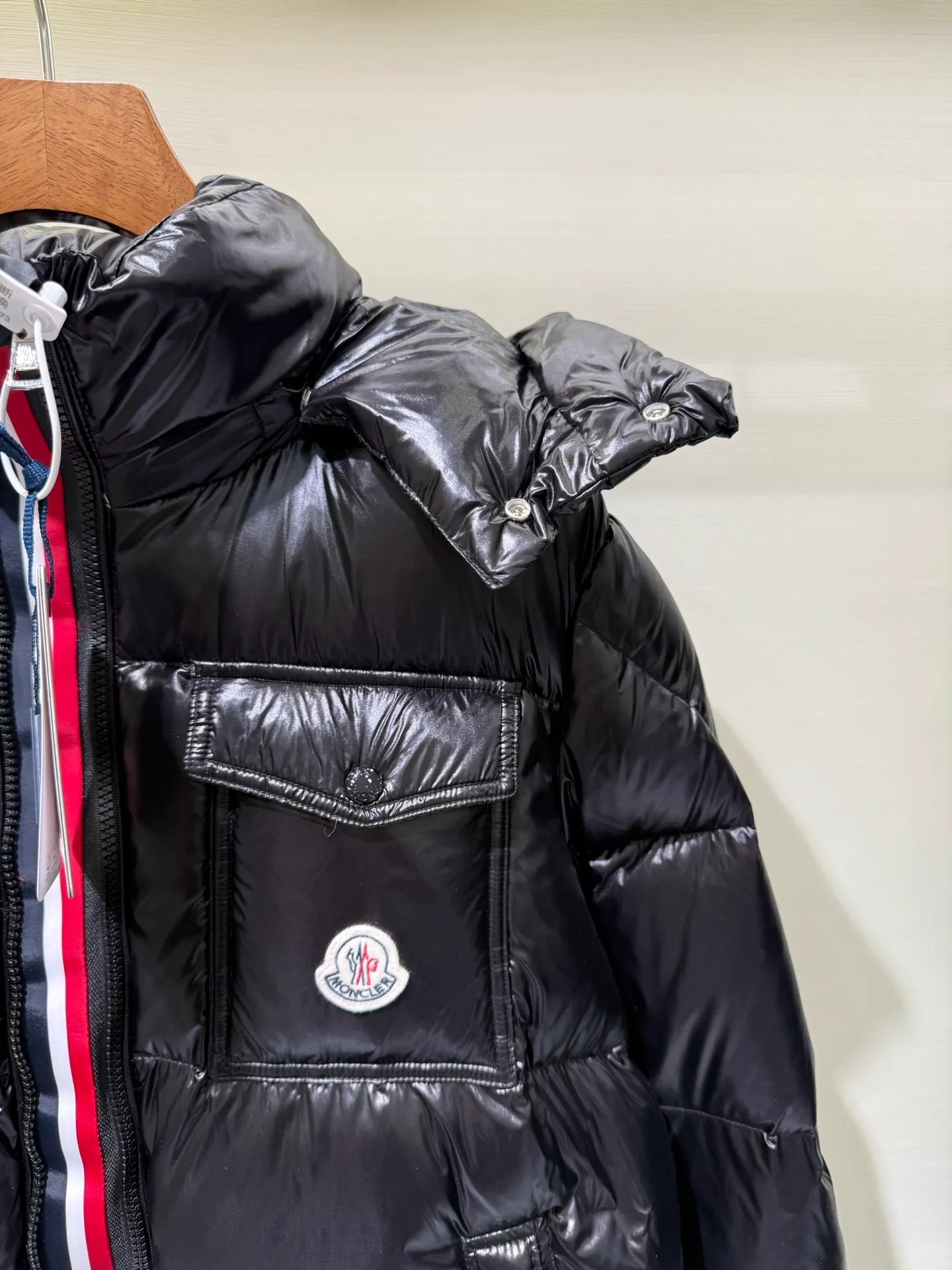 P1180 Moncler Montbeliard glossy down jacket The Montbeliard down jacket is made of shiny patent nylon and features highly recognizable rectangular quilting. Featuring a hooded design and signature patch pocket at chest.  Fabric: 100% nylon Filling content: 90% white goose down 250-300g Craftsmanship: Made of nylon laqué fabric Nylon laque lining Filled with down, detachable and adjustable hood with drawstring closure Built-in flap with webbing, black pocket details at the lower end Zipper closure Collar with snap buttons Zipper pockets Patch pockets with snap buttons Adjustable cuffs Adjustable elastic drawstring hem.  Size: 1 2 3 4 5 0548000