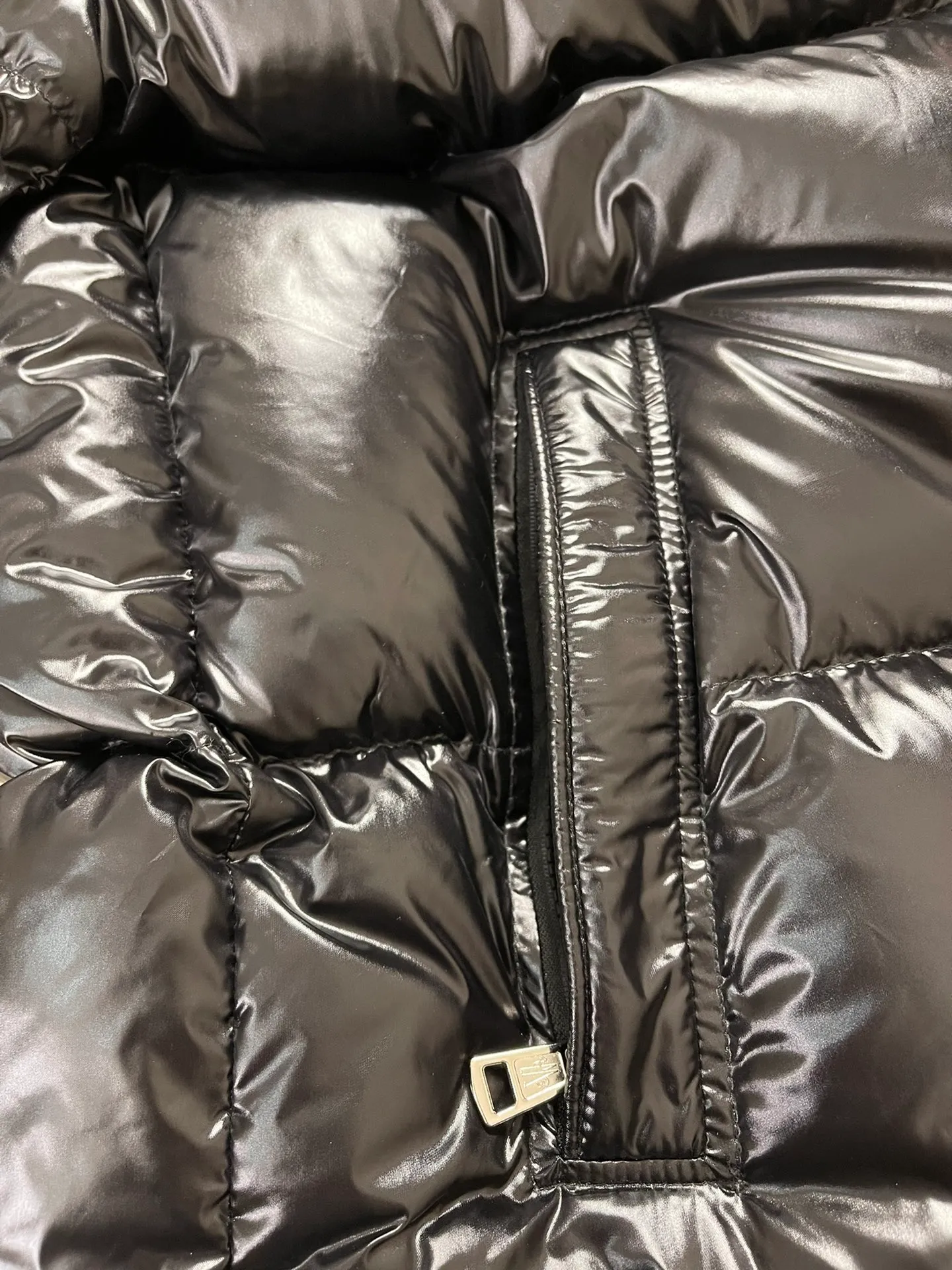 P1180 Moncler Montbeliard glossy down jacket The Montbeliard down jacket is made of shiny patent nylon and features highly recognizable rectangular quilting. Featuring a hooded design and signature patch pocket at chest.  Fabric: 100% nylon Filling content: 90% white goose down 250-300g Craftsmanship: Made of nylon laqué fabric Nylon laque lining Filled with down, detachable and adjustable hood with drawstring closure Built-in flap with webbing, black pocket details at the lower end Zipper closure Collar with snap buttons Zipper pockets Patch pockets with snap buttons Adjustable cuffs Adjustable elastic drawstring hem.  Size: 1 2 3 4 5 0548000