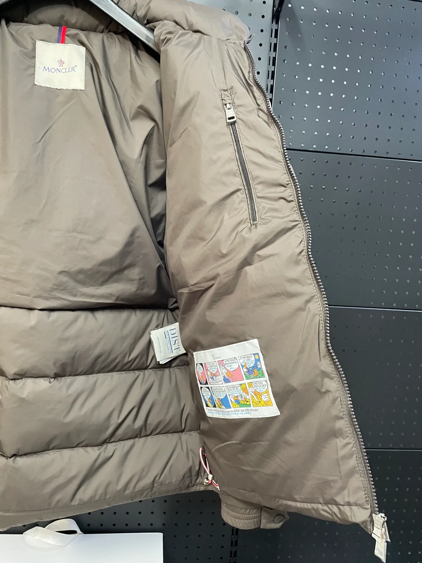 P840 🆕❤️2️⃣0️⃣2️⃣4️⃣🆕Premium down⬆️Moncler Solayan men's three-color trim short down jacket. Premium goose down filling. The finest, lightest and neatest fabric. Solayan men's short down jacket is decorated with seasonal iconic stripe details, blending sportsmanship and timeless style.  The Solayan down jacket is made of micro chic fabric and has a tough square shape design, highlighting Moncler's sporty spirit. This cropped down jacket features tricolor stripes on the sleeves, a seasonal take on the brand's signature. Comes with a practical pull-out hood. Details •Made from micro chic nylon fabric •Micro chic nylon lining •Down filled •Pull-out hood •Zip closure •Zip pockets •Adjustable cuffs •Elastic drawstring hem •Tri-color trim on sleeves Size: 1-5 Color: White Dark Brown Black