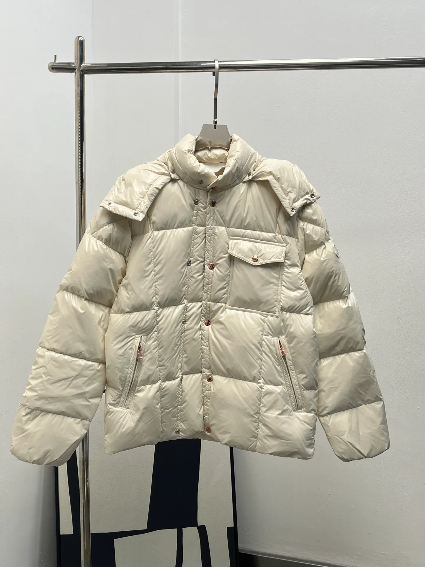 P1160 Moncler 25 new serfanto hooded buttoned down jacket for men and women. This hooded warm piece is equipped with double snap button closure to create an asymmetrical shape. Trimmed with quilting in varying sizes for a geometric feel