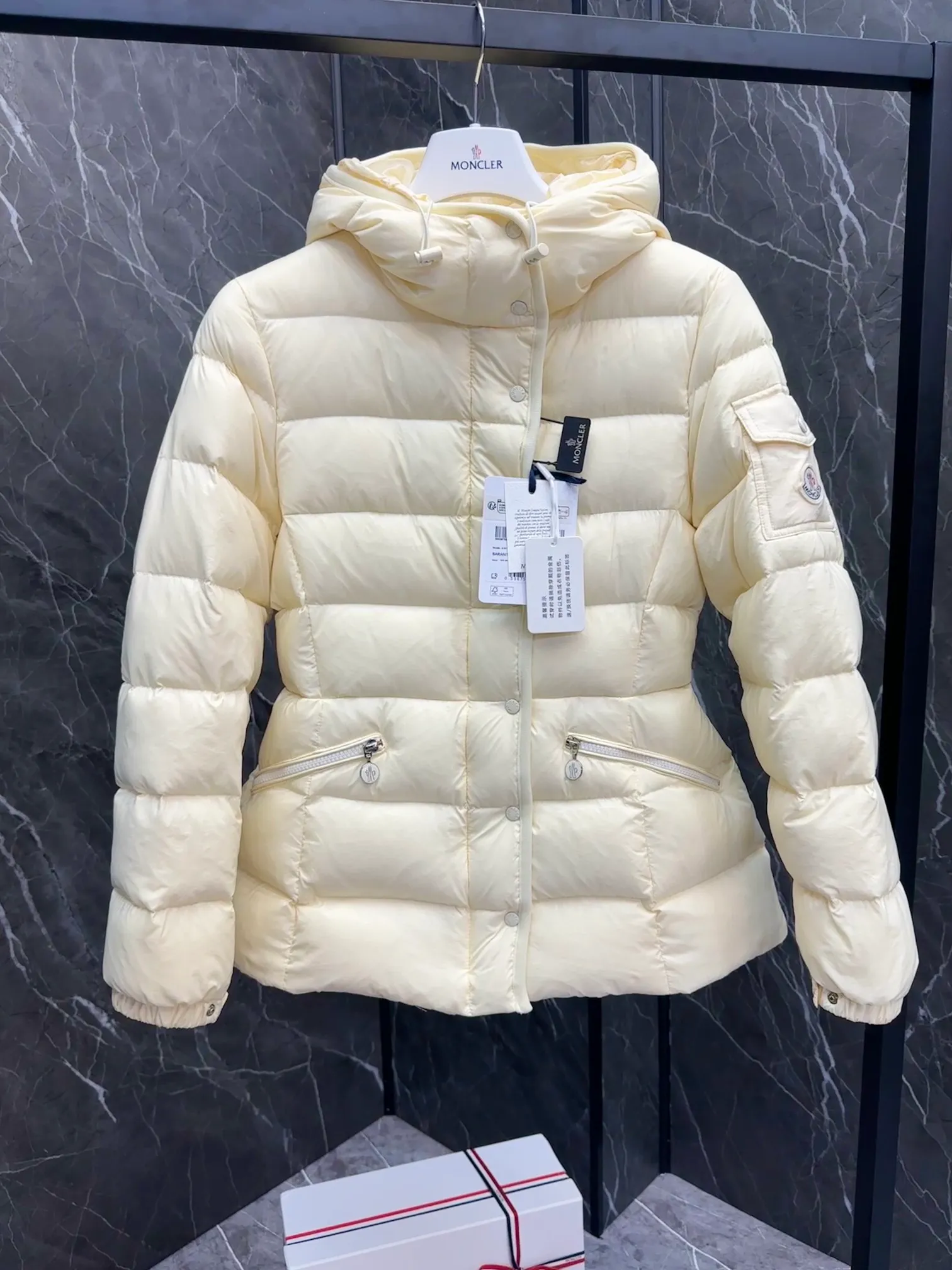 P780 Hot Sale ⬆️Moncler Barante Women’s Short Down Jacket The Barante short down jacket combines femininity with practical functions, reinterpreting the aesthetic style of the 1970s for modern women. The Barante down jacket is made from lustrous nylon and is inspired by the 1970s. It adopts a waist design and presents an A-line silhouette, highlighting a feminine style. An adjustable hood and signature logo patch add finishing touches. Details •Made of nylon laqué fabric •Nylon laqué lining •Down filling •Adjustable hood •Zip and snap closure •Suit pocket •Adjustable cuffs Size : 0-3. Snow White/Light Pink/Black.