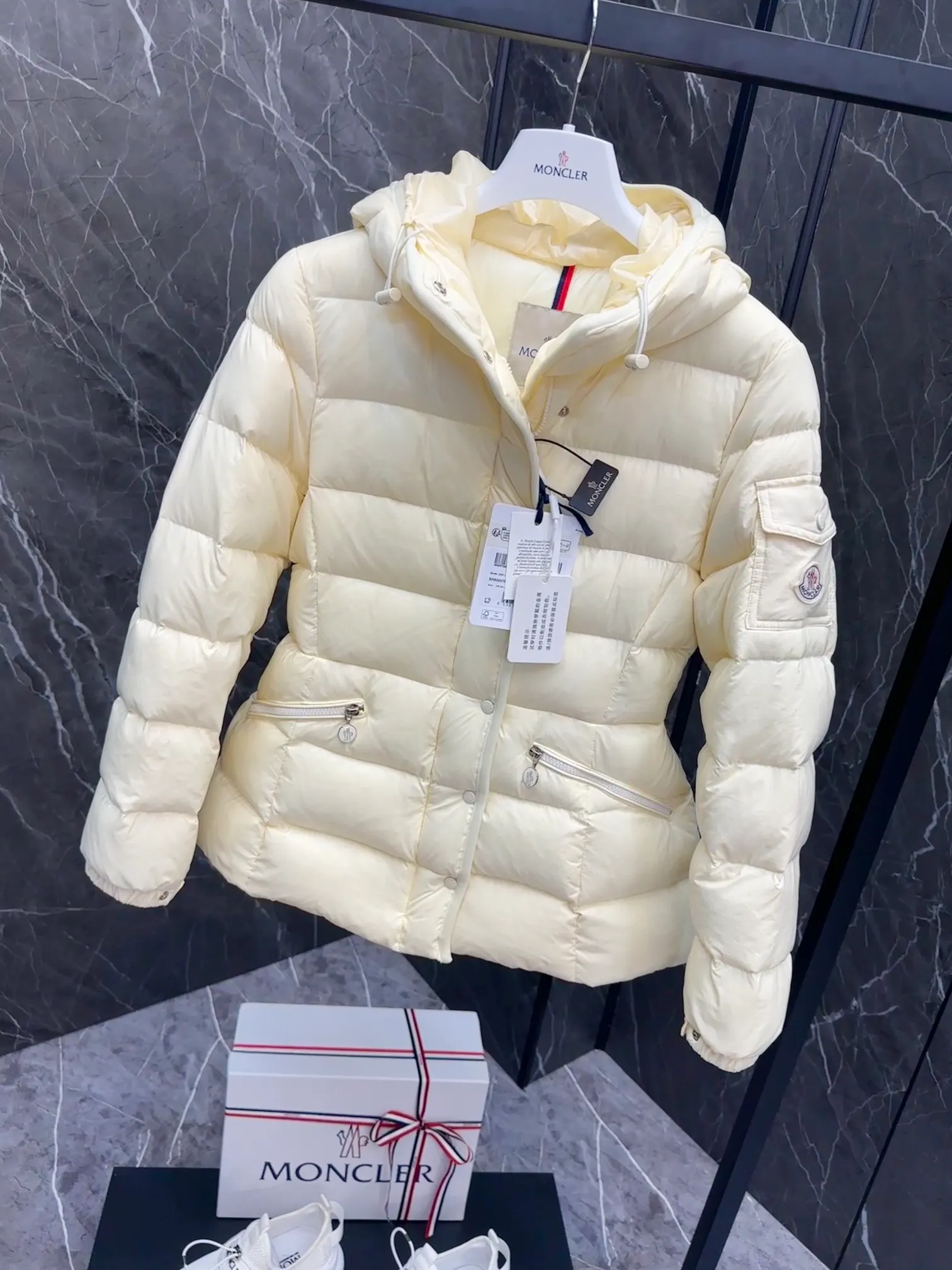 P780 Hot Sale ⬆️Moncler Barante Women’s Short Down Jacket The Barante short down jacket combines femininity with practical functions, reinterpreting the aesthetic style of the 1970s for modern women. The Barante down jacket is made from lustrous nylon and is inspired by the 1970s. It adopts a waist design and presents an A-line silhouette, highlighting a feminine style. An adjustable hood and signature logo patch add finishing touches. Details •Made of nylon laqué fabric •Nylon laqué lining •Down filling •Adjustable hood •Zip and snap closure •Suit pocket •Adjustable cuffs Size : 0-3. Snow White/Light Pink/Black.