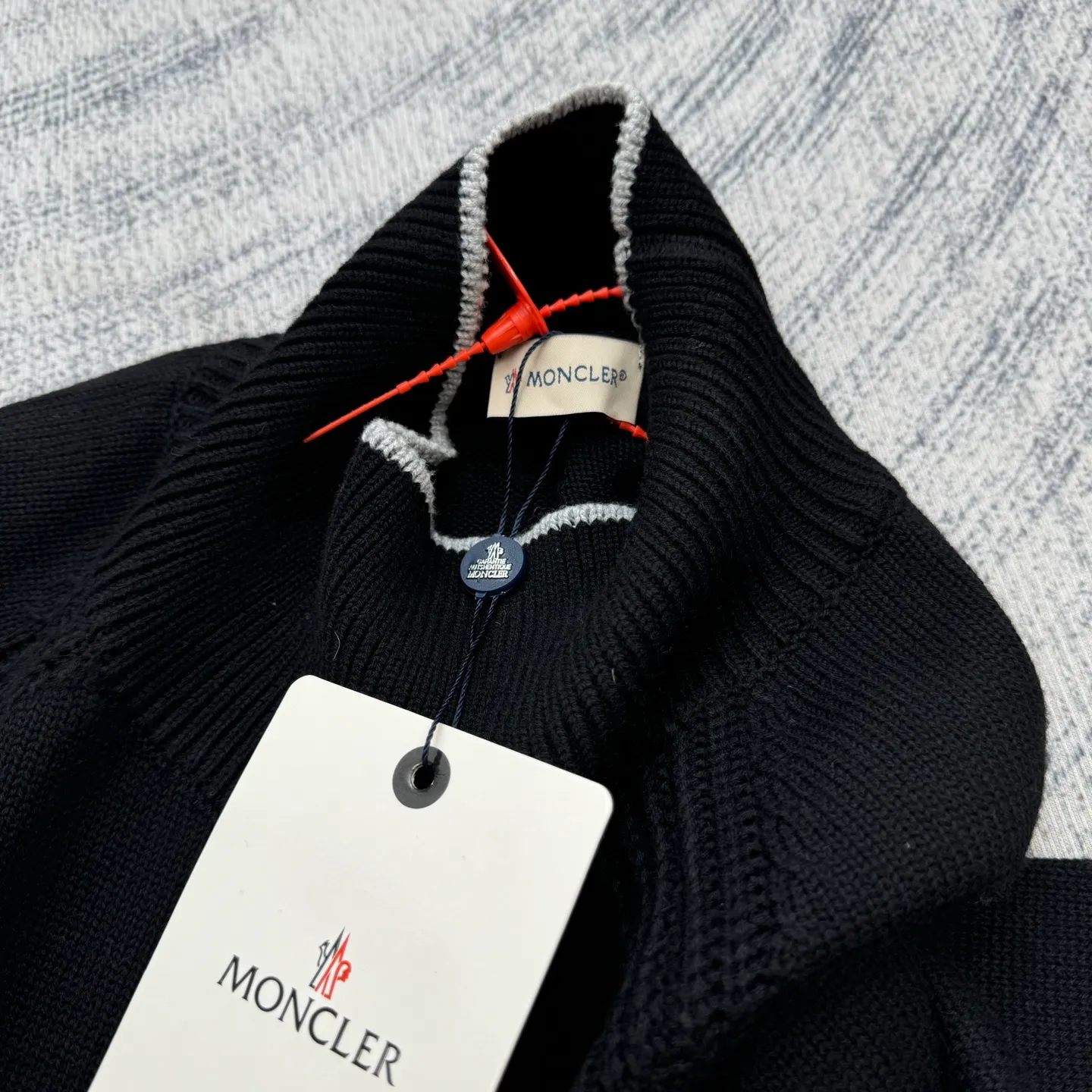 P430 Moncler Mouth Logo High Neck Knitted Long Sleeve Sweater Size: S/M/L/XL The sweater adopts high collar knitting technology, and the neck texture is tight and elastic, which is both warm and stylish. In terms of detailed craftsmanship, hollow knitting splicing technology is used on the shoulders, with fine texture and distinct layers, which enhances the design sense of the body; the contrasting rib technology on the cuffs and hem forms a soft contrast with the main color, improving the overall sophistication; the brand logo on the left arm uses three-dimensional embroidery technology, with precise stitching, highlighting the brand recognition. Made of high-quality knitted fabrics and made with fine weaving technology, it is skin-friendly, comfortable and has a crisp silhouette. From the warm design of the collar to the details of the embroidery, every craftsmanship reflects the brand's dual pursuit of quality and fashion. It is an autumn and winter item that combines practicality and design. Purchase the original version for development, order the color and dye it, and feel free to compare it with any version on the market!