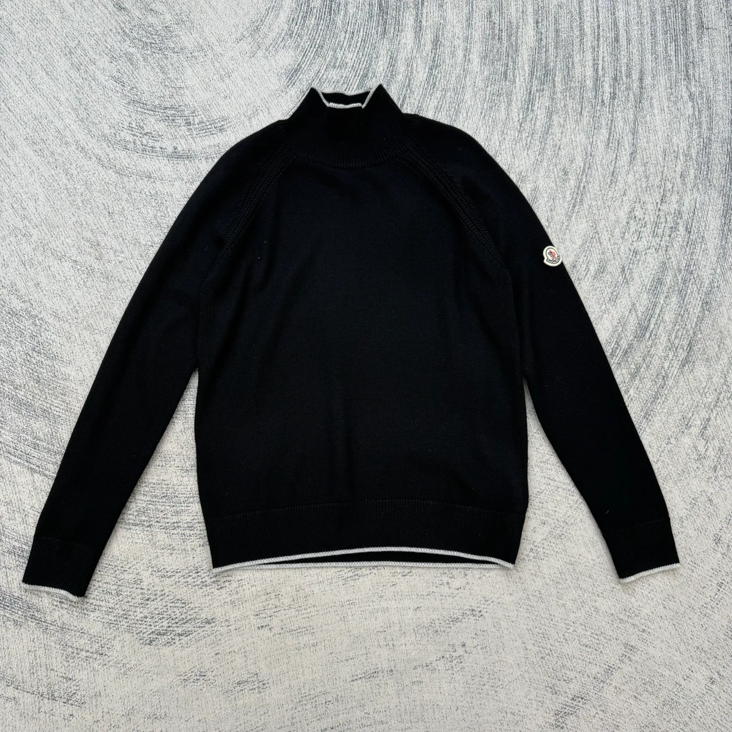 P430 Moncler Mouth Logo High Neck Knitted Long Sleeve Sweater Size: S/M/L/XL The sweater adopts high collar knitting technology, and the neck texture is tight and elastic, which is both warm and stylish. In terms of detailed craftsmanship, hollow knitting splicing technology is used on the shoulders, with fine texture and distinct layers, which enhances the design sense of the body; the contrasting rib technology on the cuffs and hem forms a soft contrast with the main color, improving the overall sophistication; the brand logo on the left arm uses three-dimensional embroidery technology, with precise stitching, highlighting the brand recognition. Made of high-quality knitted fabrics and made with fine weaving technology, it is skin-friendly, comfortable and has a crisp silhouette. From the warm design of the collar to the details of the embroidery, every craftsmanship reflects the brand's dual pursuit of quality and fashion. It is an autumn and winter item that combines practicality and design. Purchase the original version for development, order the color and dye it, and feel free to compare it with any version on the market!