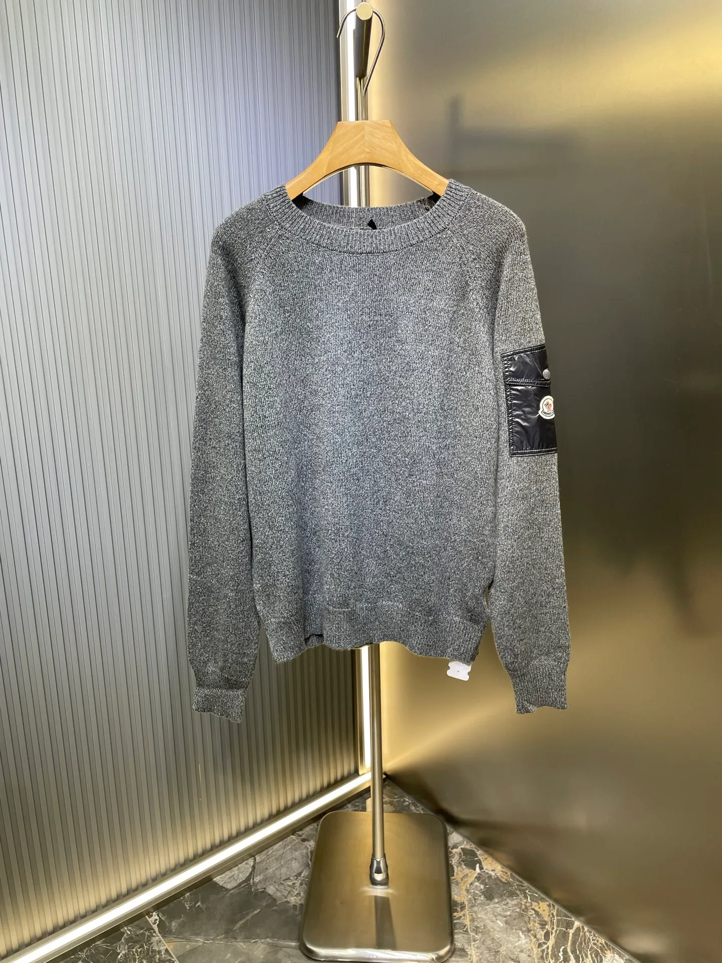 P390 Moncler Hooded Sleeve Pocket Crew Neck Sweater was originally purchased and developed for RMB 6,950. The fabric is made of 30% wool double-ply blended wool. The main body of wool ensures the warmth and comfort of the clothing. The addition of a small amount of nylon and spandex significantly improves the elasticity and wear resistance. The ribbed decorative parts are made of 100% wool, which further enhances the overall texture. Through a high needle count and fine gauge loom, combined with the orderly direction of the internal yarn, the floating yarn is cleverly woven and stored, with almost no unnecessary thread mess. The nylon pockets on the sleeves are embellished with the brand logo, which is low-key and luxurious.  Size:S-M-L-XL