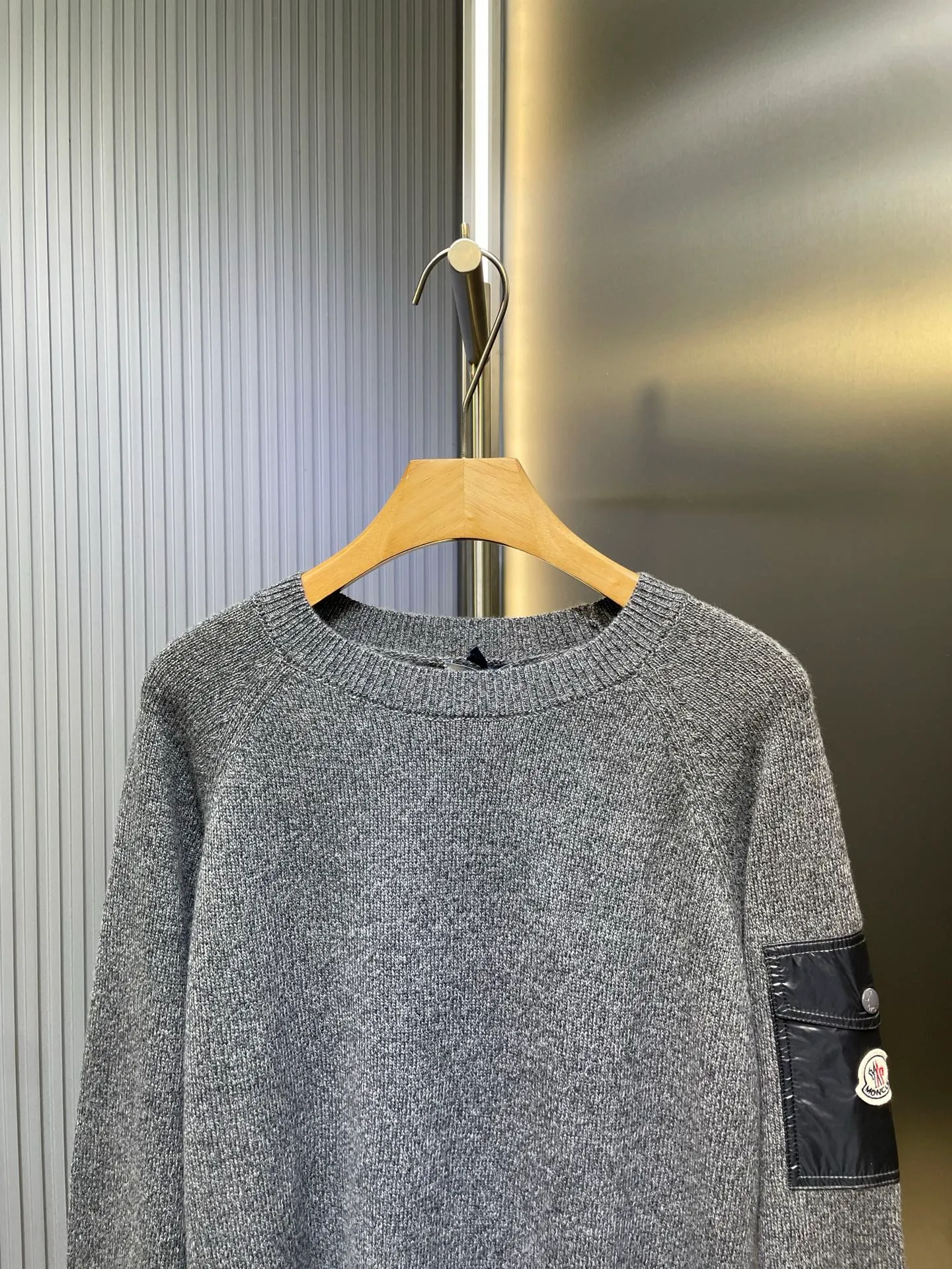 P390 Moncler Hooded Sleeve Pocket Crew Neck Sweater was originally purchased and developed for RMB 6,950. The fabric is made of 30% wool double-ply blended wool. The main body of wool ensures the warmth and comfort of the clothing. The addition of a small amount of nylon and spandex significantly improves the elasticity and wear resistance. The ribbed decorative parts are made of 100% wool, which further enhances the overall texture. Through a high needle count and fine gauge loom, combined with the orderly direction of the internal yarn, the floating yarn is cleverly woven and stored, with almost no unnecessary thread mess. The nylon pockets on the sleeves are embellished with the brand logo, which is low-key and luxurious.  Size:S-M-L-XL