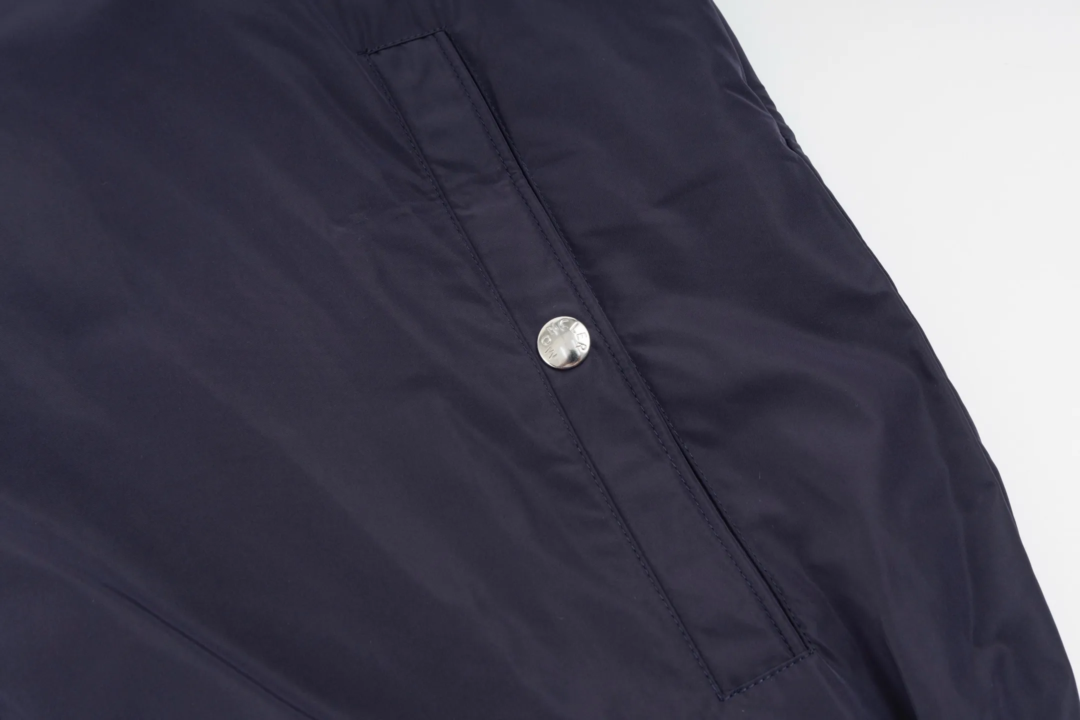 P550 Exclusive supply] Moncler Webbing Armband Lightweight Jacket (Navy Blue) The fabric is made of 100% polyester fiber to create a tough protective outer layer. It is known for its excellent tear resistance and wear resistance. It can quickly return to flatness during wearing and maintain the crisp and stylish appearance of the clothing for a long time. At the same time, it is not easy to deform after being washed for a long time. Decorative edging in two different colors has been added to the center section of the sleeves. This design element not only adds visual highlights to the clothing, making it more fashionable and unique, the webbing is precisely positioned along the specified contours from the cuffs to the seam of the collar to ensure symmetry and overall smoothness. Before actual sewing, use very fine basting stitches for pre-fixing. This step is crucial to prevent the webbing from slipping, twisting, or wrinkling during sewing and ensuring that the final stitch is straight and perfect. Size:1/2/3/4