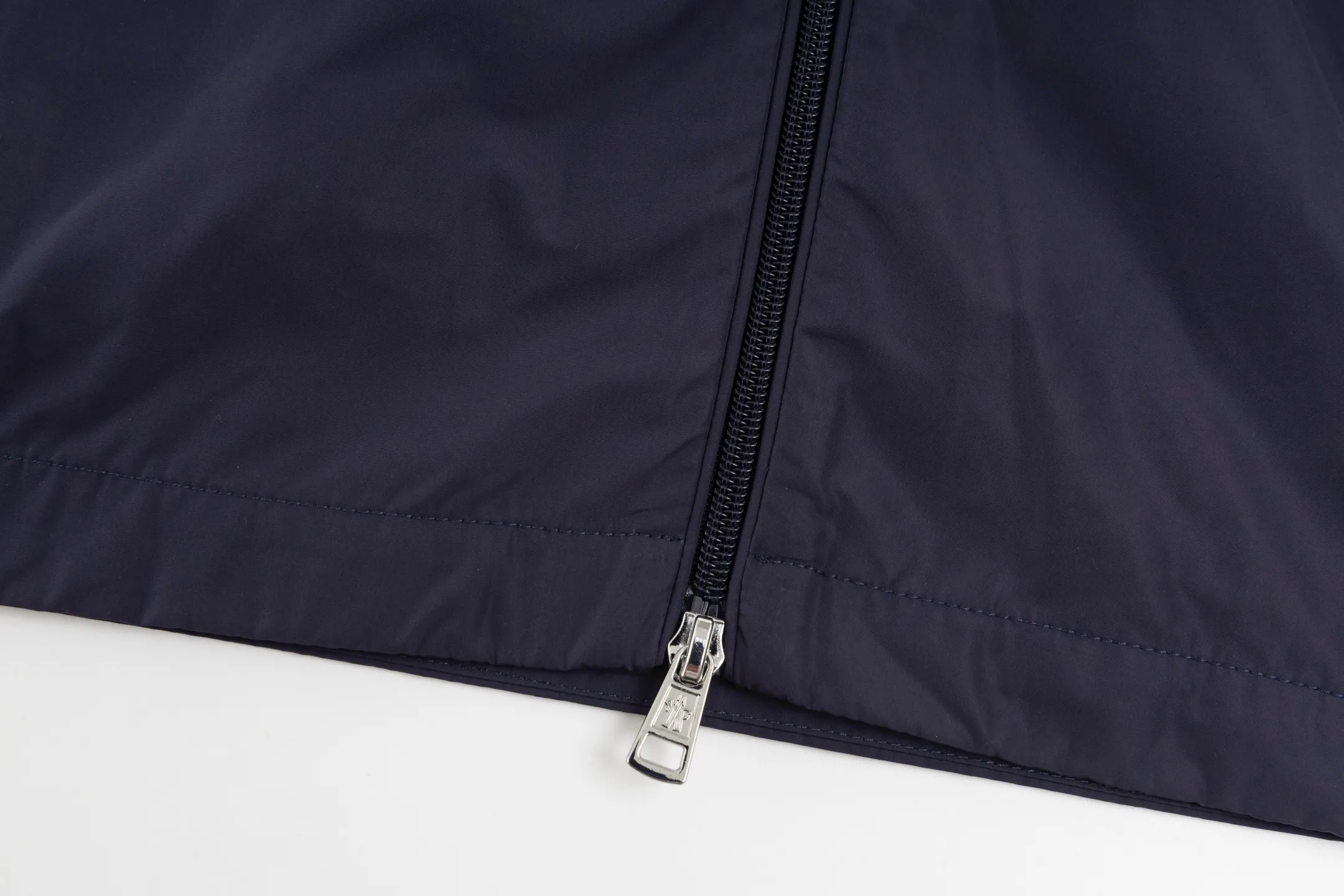 P550 Exclusive supply] Moncler Webbing Armband Lightweight Jacket (Navy Blue) The fabric is made of 100% polyester fiber to create a tough protective outer layer. It is known for its excellent tear resistance and wear resistance. It can quickly return to flatness during wearing and maintain the crisp and stylish appearance of the clothing for a long time. At the same time, it is not easy to deform after being washed for a long time. Decorative edging in two different colors has been added to the center section of the sleeves. This design element not only adds visual highlights to the clothing, making it more fashionable and unique, the webbing is precisely positioned along the specified contours from the cuffs to the seam of the collar to ensure symmetry and overall smoothness. Before actual sewing, use very fine basting stitches for pre-fixing. This step is crucial to prevent the webbing from slipping, twisting, or wrinkling during sewing and ensuring that the final stitch is straight and perfect. Size:1/2/3/4