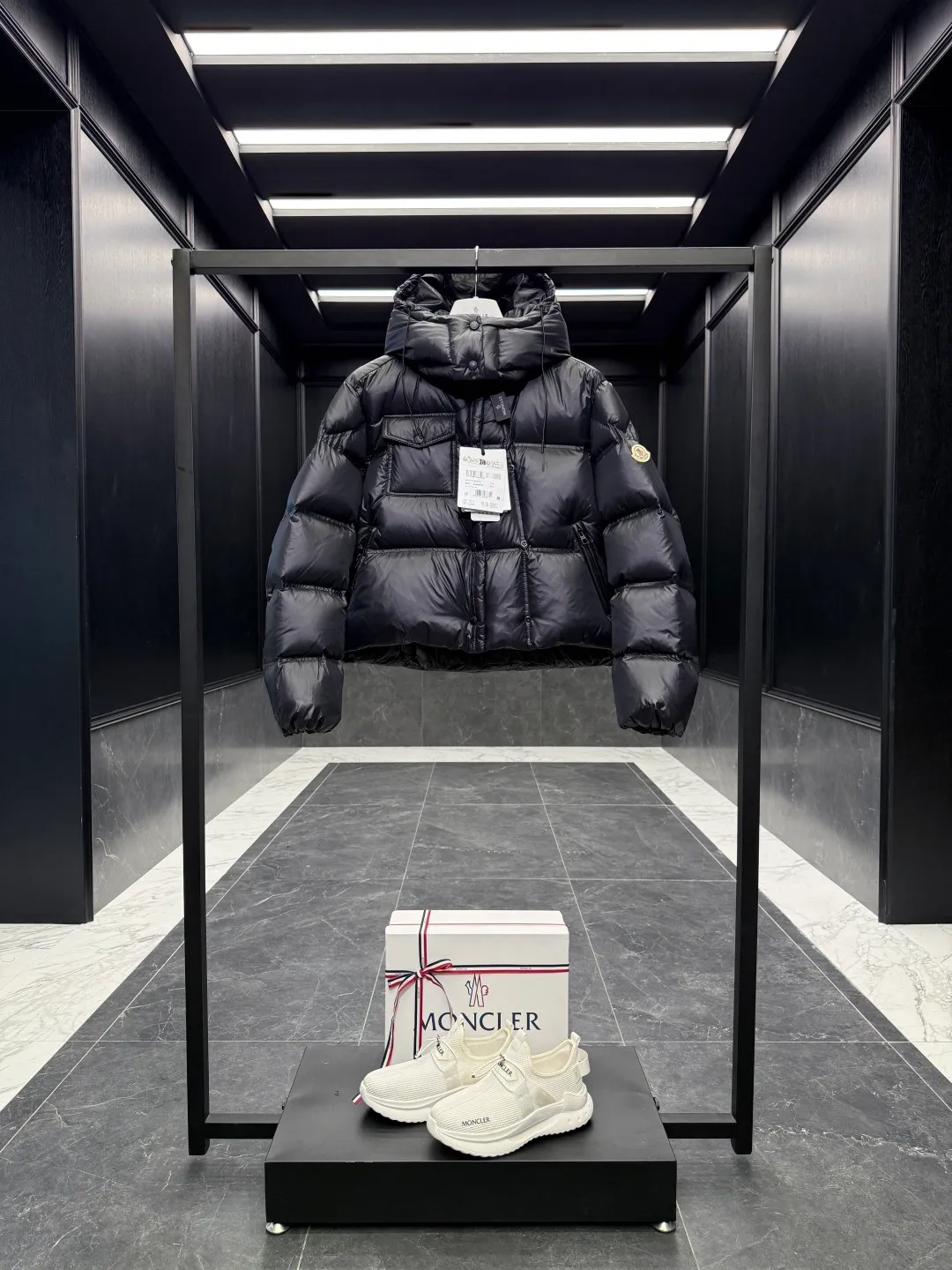 P900 Special down  The Erea down jacket is a modern take on shapes and textures. Short design in functional super laqué nylon with a glossy finish. This hooded insulated piece features a double-snap closure for an asymmetrical shape. The body and sleeves are quilted in varying sizes for a geometric feel. Details •Made from super laqué fabric •Nylon lining •Down filled •Removable and adjustable hood •Zip and snap closure •Zipper pockets •Snap fastening on chest pocket •Drawstring hem •Color Black/Cream White/Light Green Size: 0-2 Fairy Style D00730