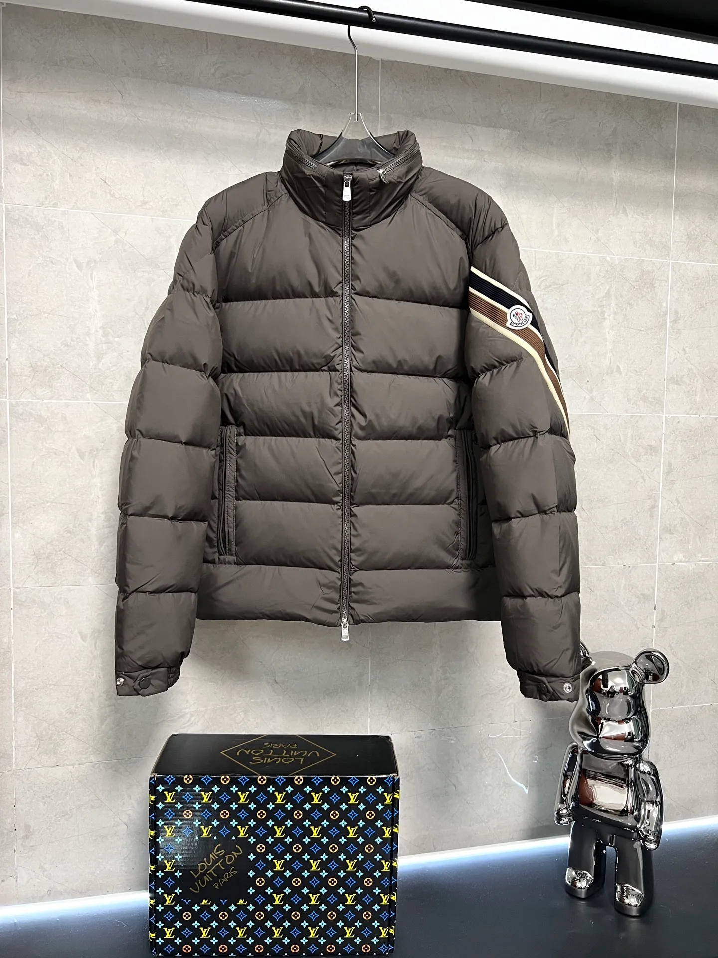 P880 MonclerSolayan men's short down jacket is decorated with seasonal iconic stripe details, blending sportsmanship and timeless style. Solayan down is made of micro chic fabrics and has a tough square shape design, highlighting Moncler's sportsmanship. This cropped style features tricolor stripes on the sleeves for a seasonal interpretation of the brand's signature. Comes with a practical pull-out hood. Color: Black Dark Brown Size: 12345