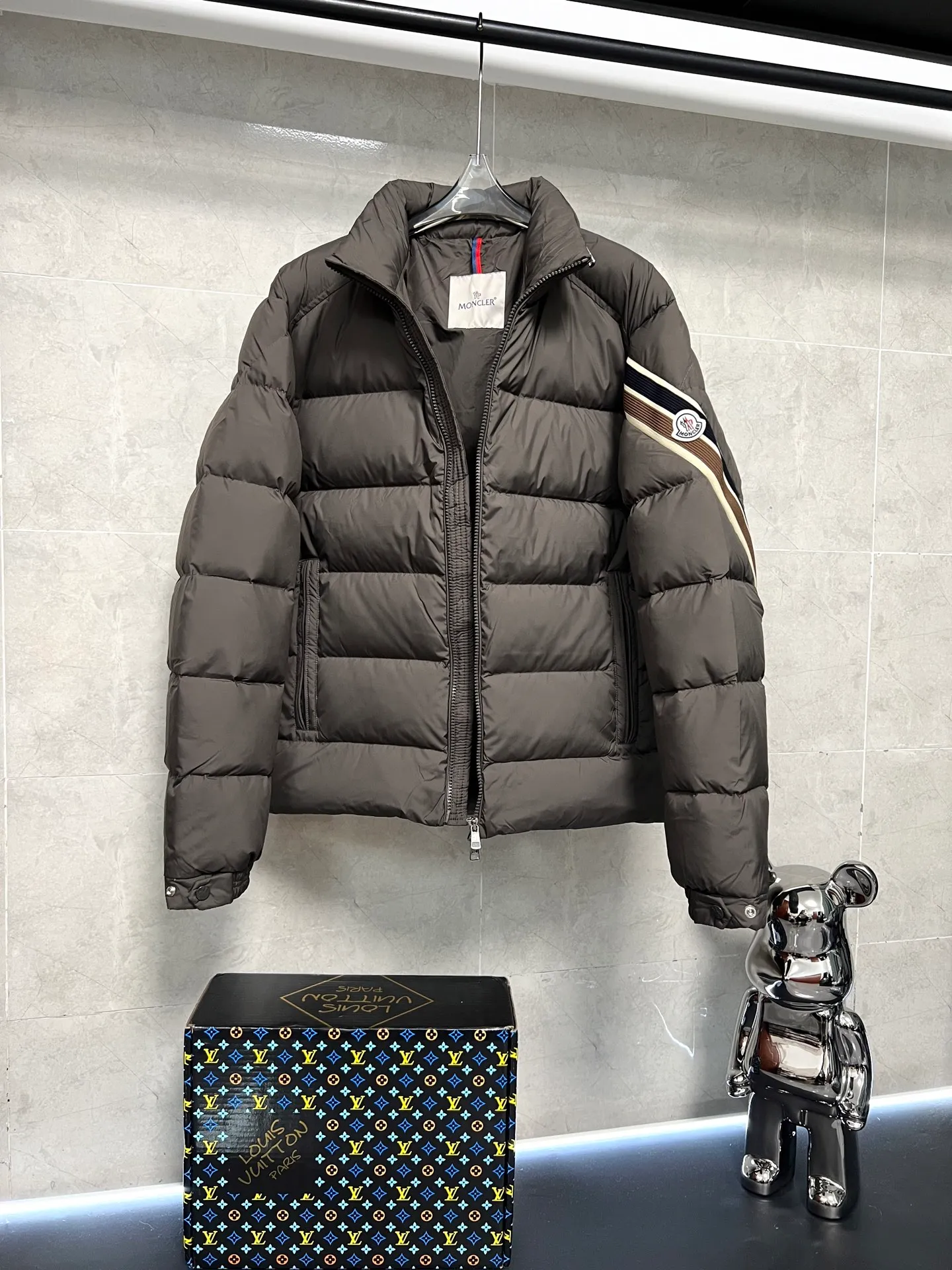P880 MonclerSolayan men's short down jacket is decorated with seasonal iconic stripe details, blending sportsmanship and timeless style. Solayan down is made of micro chic fabrics and has a tough square shape design, highlighting Moncler's sportsmanship. This cropped style features tricolor stripes on the sleeves for a seasonal interpretation of the brand's signature. Comes with a practical pull-out hood. Color: Black Dark Brown Size: 12345