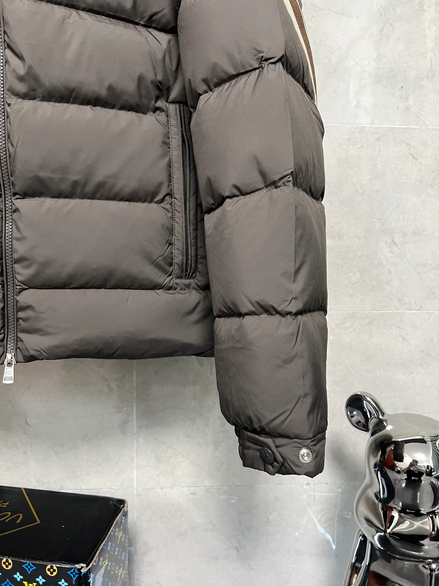 P880 MonclerSolayan men's short down jacket is decorated with seasonal iconic stripe details, blending sportsmanship and timeless style. Solayan down is made of micro chic fabrics and has a tough square shape design, highlighting Moncler's sportsmanship. This cropped style features tricolor stripes on the sleeves for a seasonal interpretation of the brand's signature. Comes with a practical pull-out hood. Color: Black Dark Brown Size: 12345