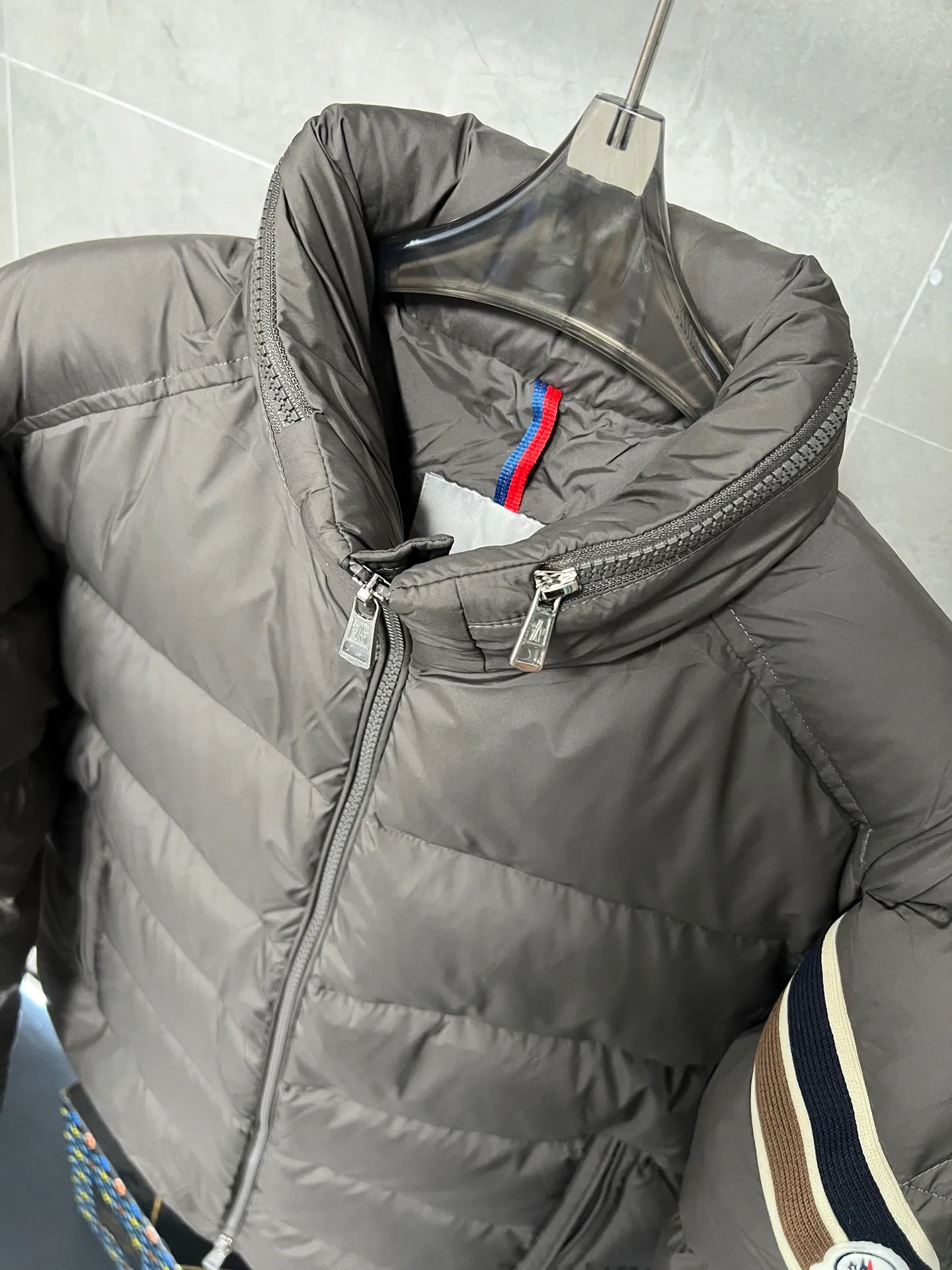 P880 MonclerSolayan men's short down jacket is decorated with seasonal iconic stripe details, blending sportsmanship and timeless style. Solayan down is made of micro chic fabrics and has a tough square shape design, highlighting Moncler's sportsmanship. This cropped style features tricolor stripes on the sleeves for a seasonal interpretation of the brand's signature. Comes with a practical pull-out hood. Color: Black Dark Brown Size: 12345