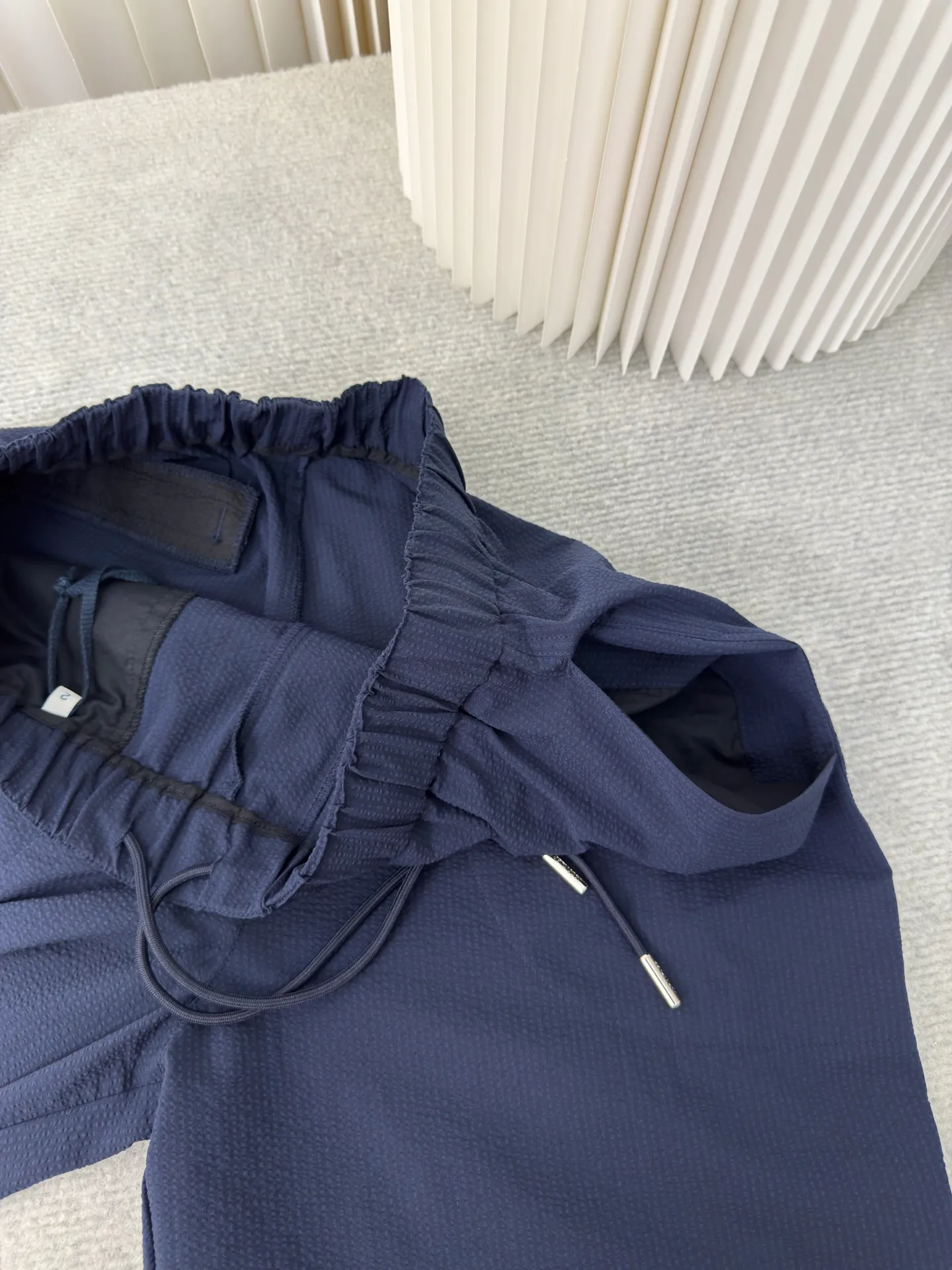 P410 MONCLER Puff Wrinkle Pants with Mouth, Authentic Open Version - Physical Counter - Top Luxury Quality 🆚Second Price of All Versions on the Market Made of cotton blended woven fabric with 76% high cotton content + 24% polyester fiber. The high cotton content ensures that the fabric is soft, skin-friendly, and has good breathability. The addition of a small amount of polyester fiber balances the wrinkle resistance and elasticity of the overall fabric and greatly reduces its shrinkage. After preshrinking, dimensional changes during washing are negligible. The fusion of the two makes the fabric combine anti-wrinkle, quick-drying, easy care and other characteristics without losing the advantages of good wearing experience and strong breathability.  The ground warp + bubble warp is independently let-off. The bubble warp yarn feeding speed is about 20% higher than the ground warp yarn feeding speed. During weaving, the bubble warp is relaxed and accumulated, forming a naturally arched bubble unit. Through the alternating arrangement of yarns and the change of floating tissue, a clear grid frame is built between the bubble units. Finally, the bubble three-dimensional effect and grid outline are locked through high-temperature heat setting. Size:1 2 3 4