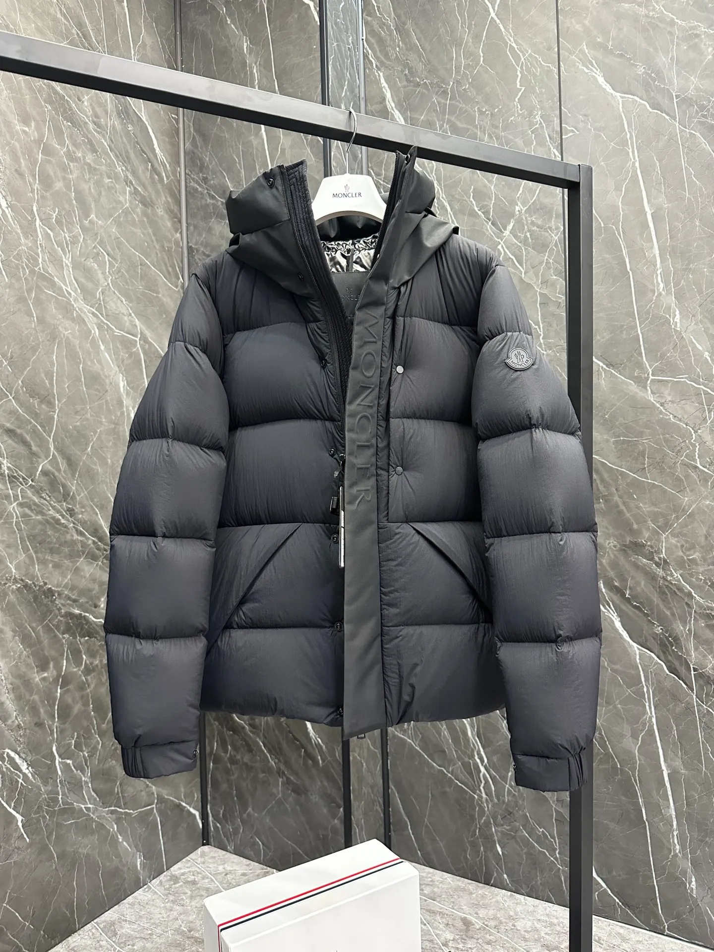 P760 Style number: Y125 Moncler Madeira short men's Madeira down jacket is specially designed for modern men who value functionality and beauty. It is suitable for wearing in various occasions such as street or skiing. Made from functional, tight nylon longue saison fabric with a padded hood and windshield for added protection. Details •Made in longue saison fabric •Nylon laqué lining •Filled with down •Hood •Embossed logo lettering •Snap and zipper closure •Pockets with zippers and snaps •Elastic drawstring hem •Logo patch Size: 1-5 Color: Black Gray White