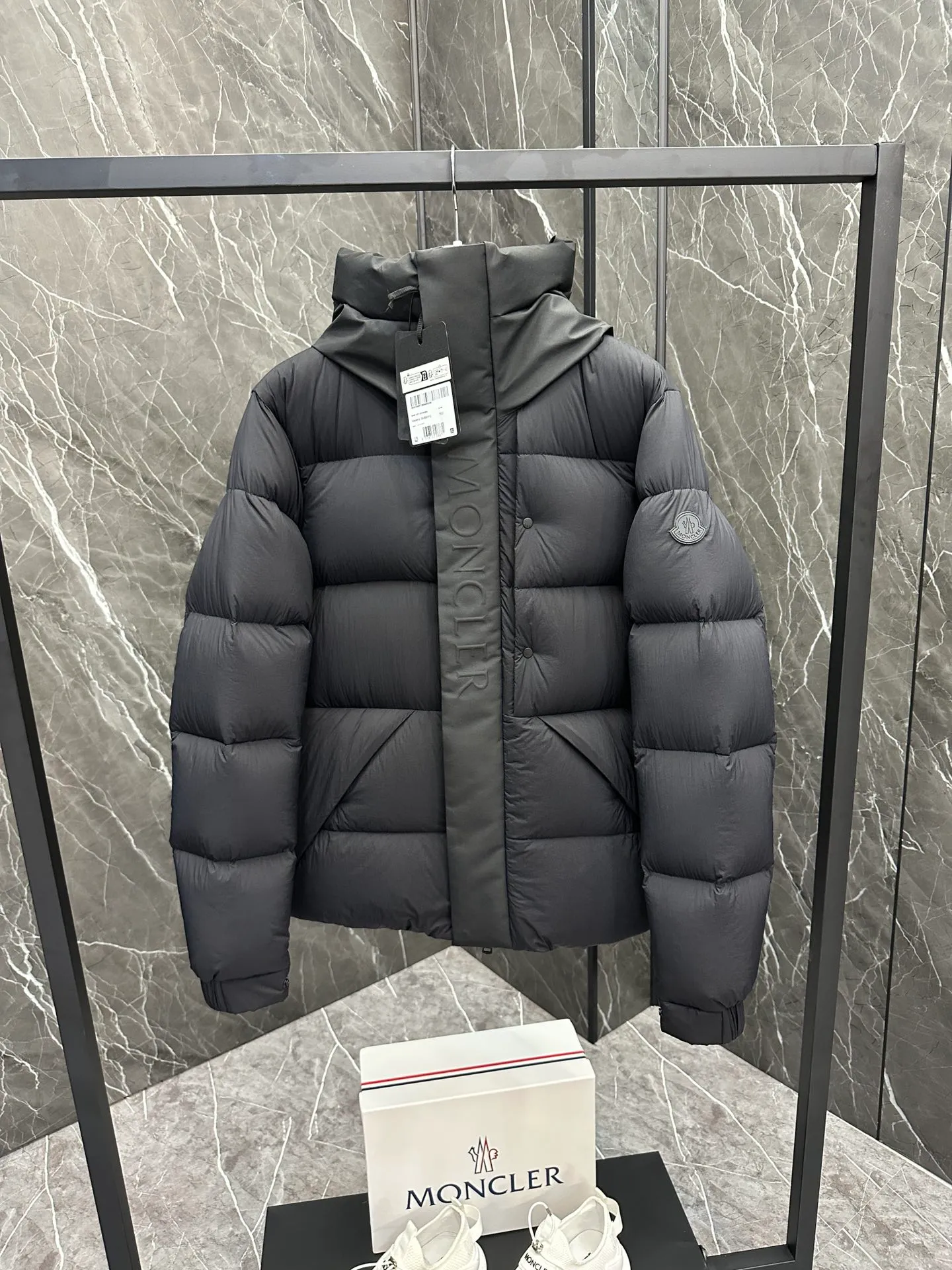 P760 Style number: Y125 Moncler Madeira short men's Madeira down jacket is specially designed for modern men who value functionality and beauty. It is suitable for wearing in various occasions such as street or skiing. Made from functional, tight nylon longue saison fabric with a padded hood and windshield for added protection. Details •Made in longue saison fabric •Nylon laqué lining •Filled with down •Hood •Embossed logo lettering •Snap and zipper closure •Pockets with zippers and snaps •Elastic drawstring hem •Logo patch Size: 1-5 Color: Black Gray White