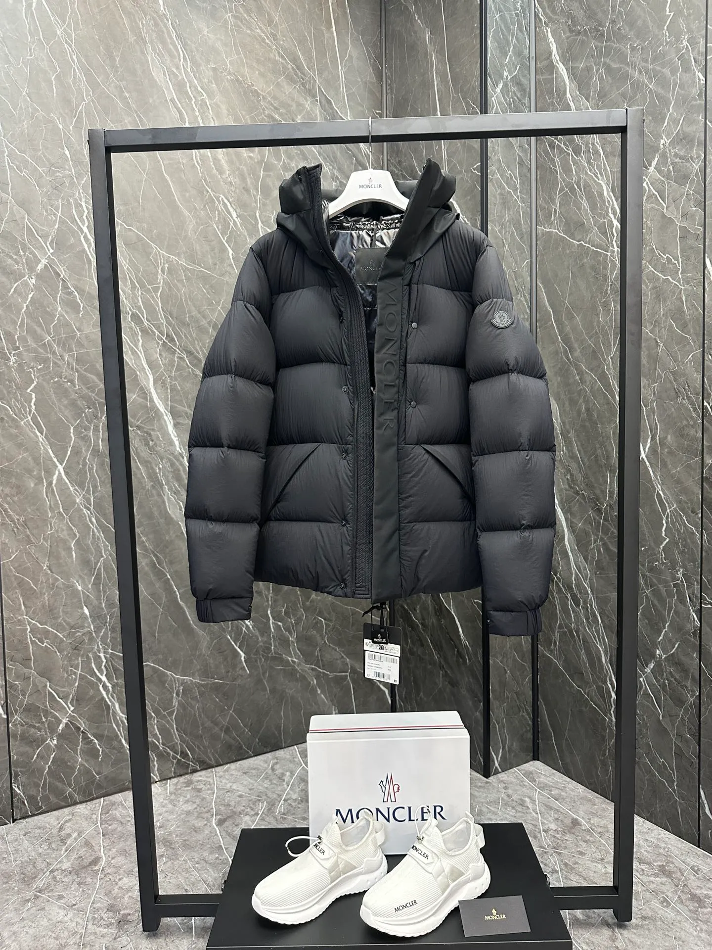 P760 Style number: Y125 Moncler Madeira short men's Madeira down jacket is specially designed for modern men who value functionality and beauty. It is suitable for wearing in various occasions such as street or skiing. Made from functional, tight nylon longue saison fabric with a padded hood and windshield for added protection. Details •Made in longue saison fabric •Nylon laqué lining •Filled with down •Hood •Embossed logo lettering •Snap and zipper closure •Pockets with zippers and snaps •Elastic drawstring hem •Logo patch Size: 1-5 Color: Black Gray White