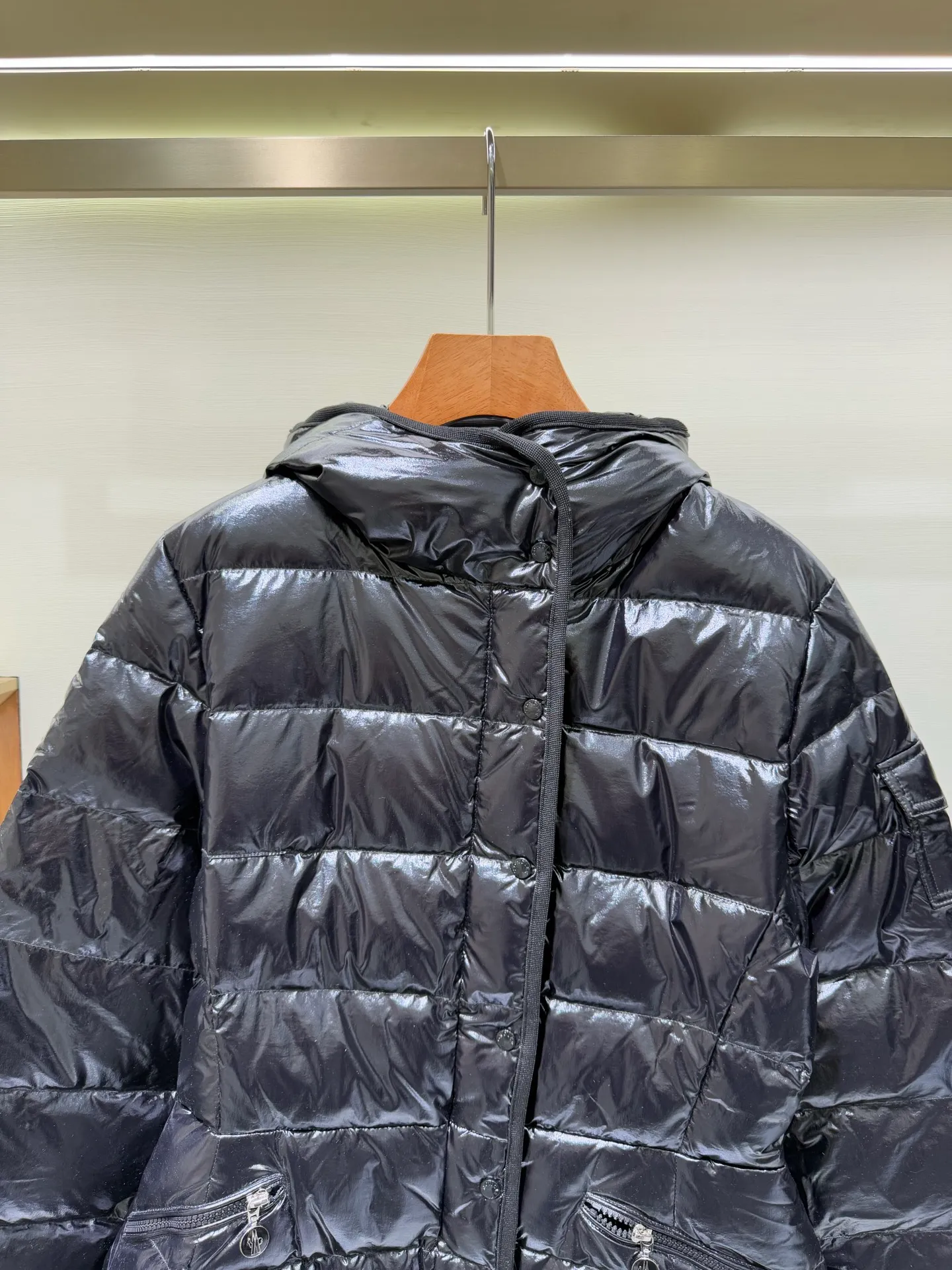 P1140 Moncler Barante series short waisted down jacket. The Barante down jacket is made of glossy nylon fabric and is inspired by the 1970s. The short version features a nipped-in waist and an A-line silhouette, highlighting a feminine style. An adjustable hood and signature logo patch add finishing touches.  Fabric: Made of nylon laque fabric, Nylon laque lining, filled with down (90 white goose down) Craftsmanship: Adjustable hood, zipper and snap button closure, zipper pocket Adjustable cuffs (supports NFC function) Color: black pink off-white Size: 0 1 2 3 4446080