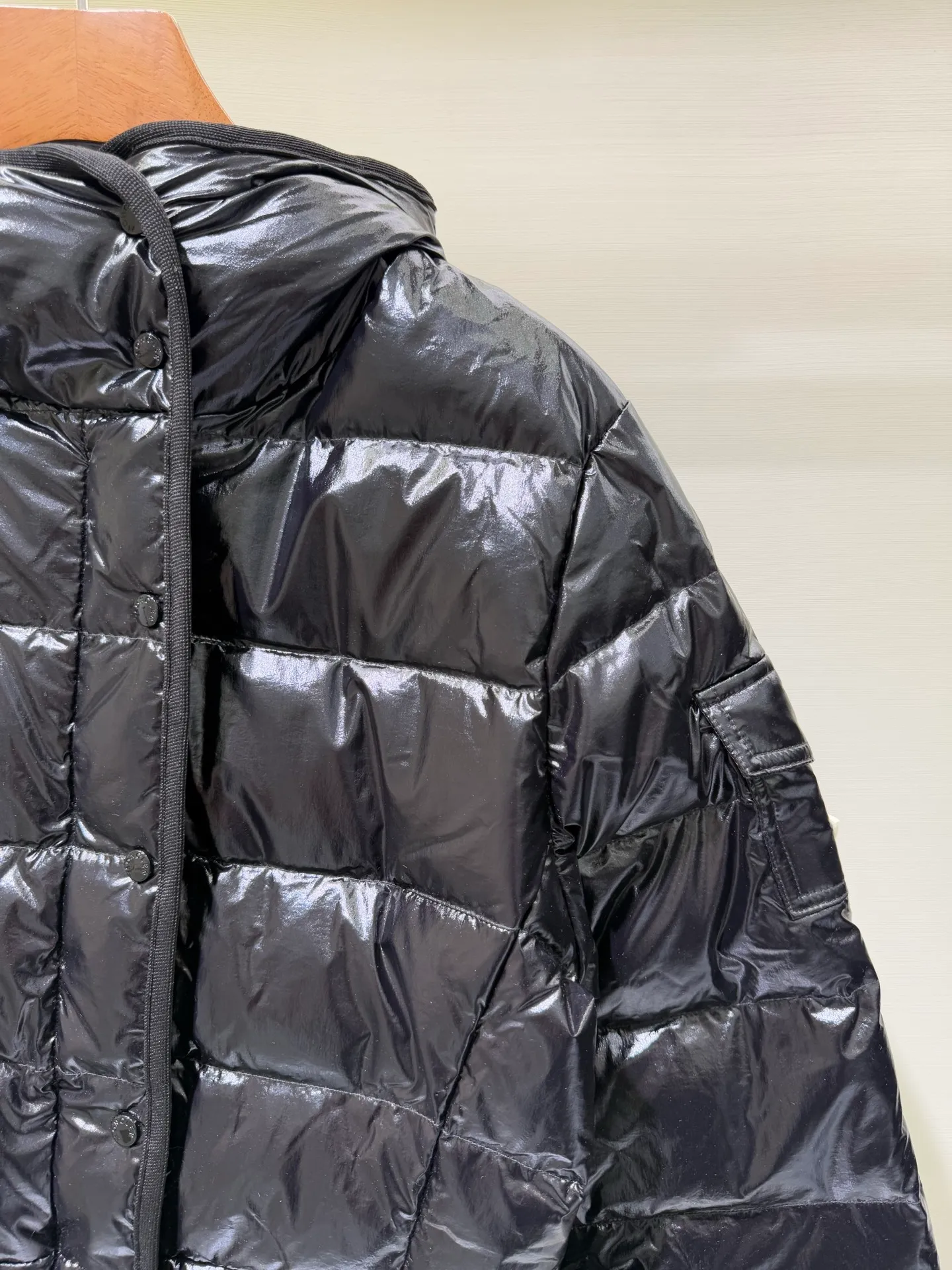 P1140 Moncler Barante series short waisted down jacket. The Barante down jacket is made of glossy nylon fabric and is inspired by the 1970s. The short version features a nipped-in waist and an A-line silhouette, highlighting a feminine style. An adjustable hood and signature logo patch add finishing touches.  Fabric: Made of nylon laque fabric, Nylon laque lining, filled with down (90 white goose down) Craftsmanship: Adjustable hood, zipper and snap button closure, zipper pocket Adjustable cuffs (supports NFC function) Color: black pink off-white Size: 0 1 2 3 4446080