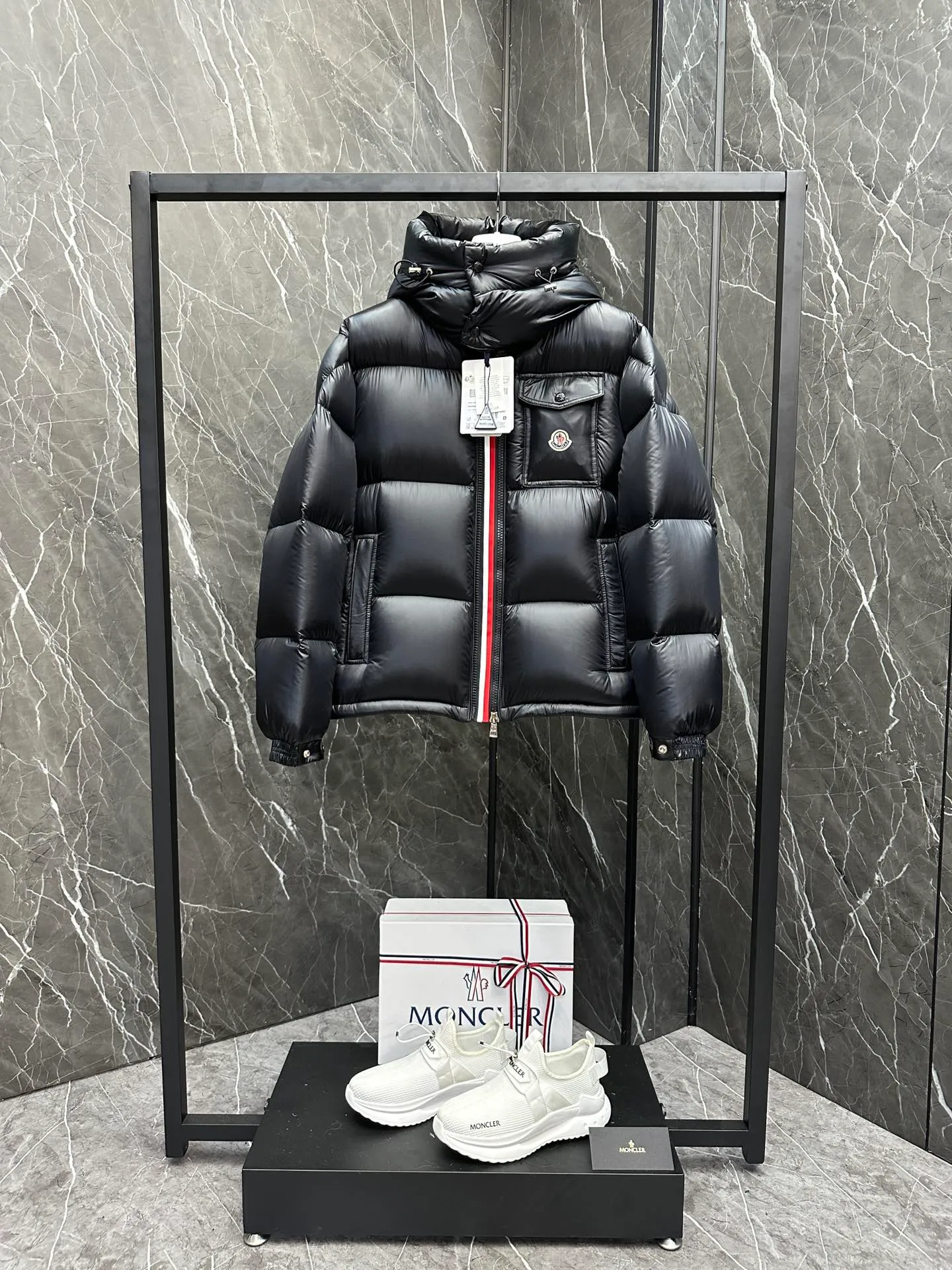 P740 ⬆️Moncler Montbeliard Short Men's Down Jacket Jacket Montbeliard Men's Short Down Jacket has warmth and protection functions, highlighting the fashionable Moncler aesthetic, and is a popular product. The Montbeliard down jacket is made from shiny patented nylon and features recognizable rectangular quilting. Featuring a hooded design and signature patch pocket at chest. Details •Made from nylon laqué fabric •Nylon laqué lining •Filled with down •Removable and adjustable hood with drawstring closure •Internal flap with webbing •Black pocket detail at lower end •Zipper closure •Snap-button closure at collar •Zipper pockets •Push-button closure at patch pockets •Adjustable cuffs •Adjustable elastic drawstring hem Size: 1-5 Couple's Black D9875067650