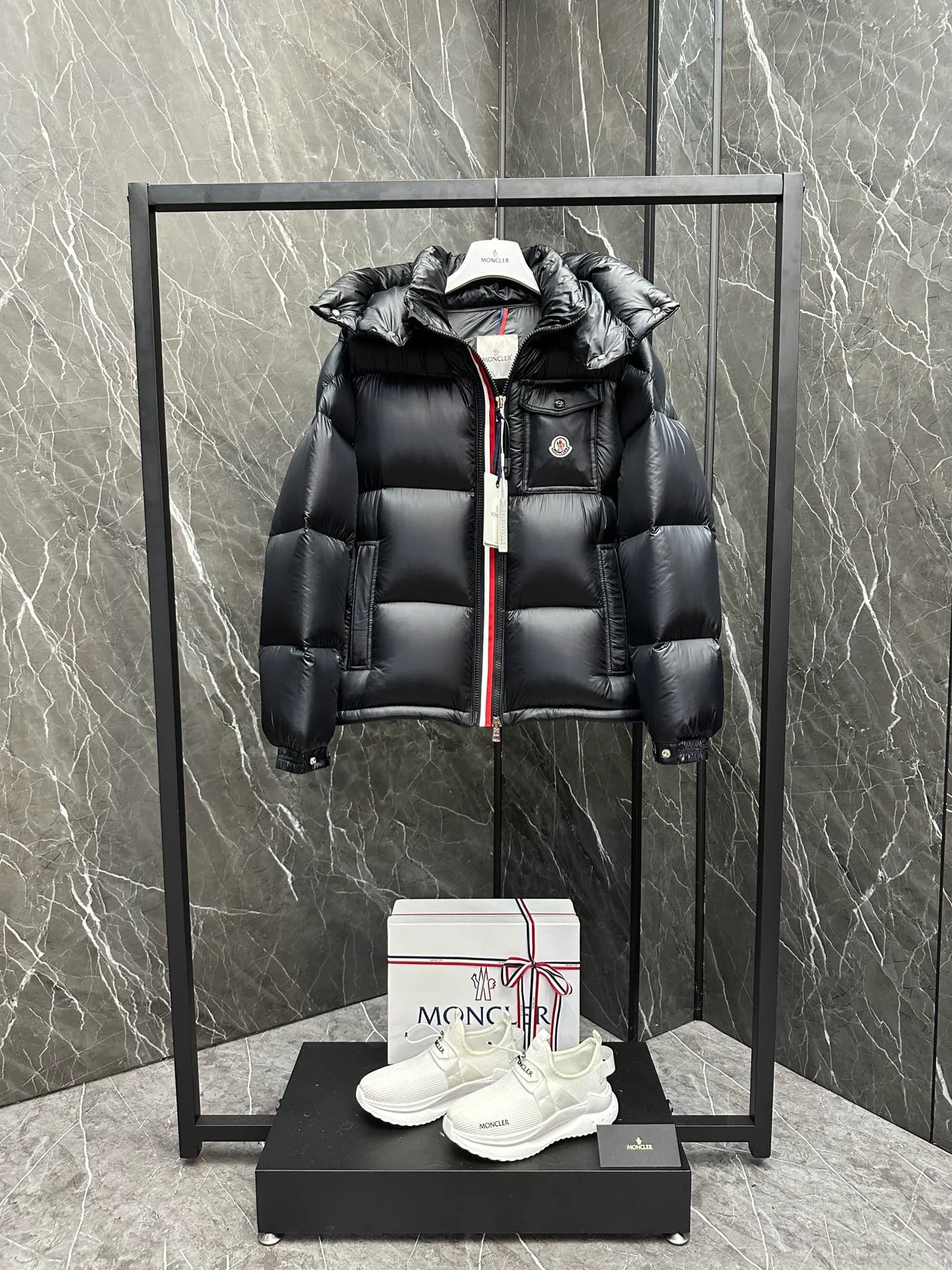 P740 ⬆️Moncler Montbeliard Short Men's Down Jacket Jacket Montbeliard Men's Short Down Jacket has warmth and protection functions, highlighting the fashionable Moncler aesthetic, and is a popular product. The Montbeliard down jacket is made from shiny patented nylon and features recognizable rectangular quilting. Featuring a hooded design and signature patch pocket at chest. Details •Made from nylon laqué fabric •Nylon laqué lining •Filled with down •Removable and adjustable hood with drawstring closure •Internal flap with webbing •Black pocket detail at lower end •Zipper closure •Snap-button closure at collar •Zipper pockets •Push-button closure at patch pockets •Adjustable cuffs •Adjustable elastic drawstring hem Size: 1-5 Couple's Black D9875067650