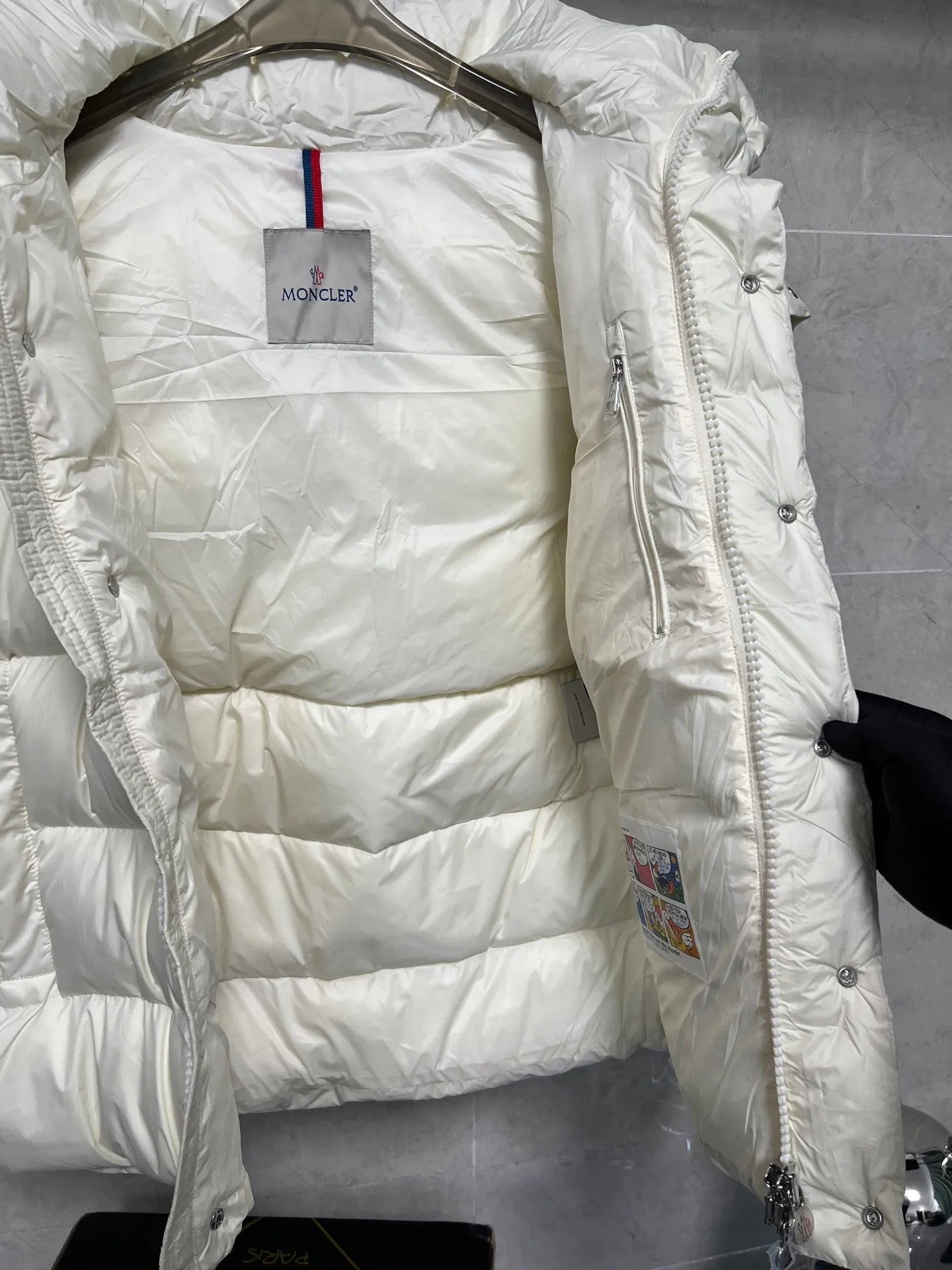 P800 Moncler matte Maya short down jacket. This short parka down jacket is made of longueSaion fabric. The garment is full of functional details to ensure warmth and care. Features removable hood, zip pockets, adjustable cuffs, and snap-zip flap fly. Logo embellished sleeves. It adds a unique touch to the overall shape and significantly improves the protective performance. Color: Black White Pink Pearl White Size: 12345