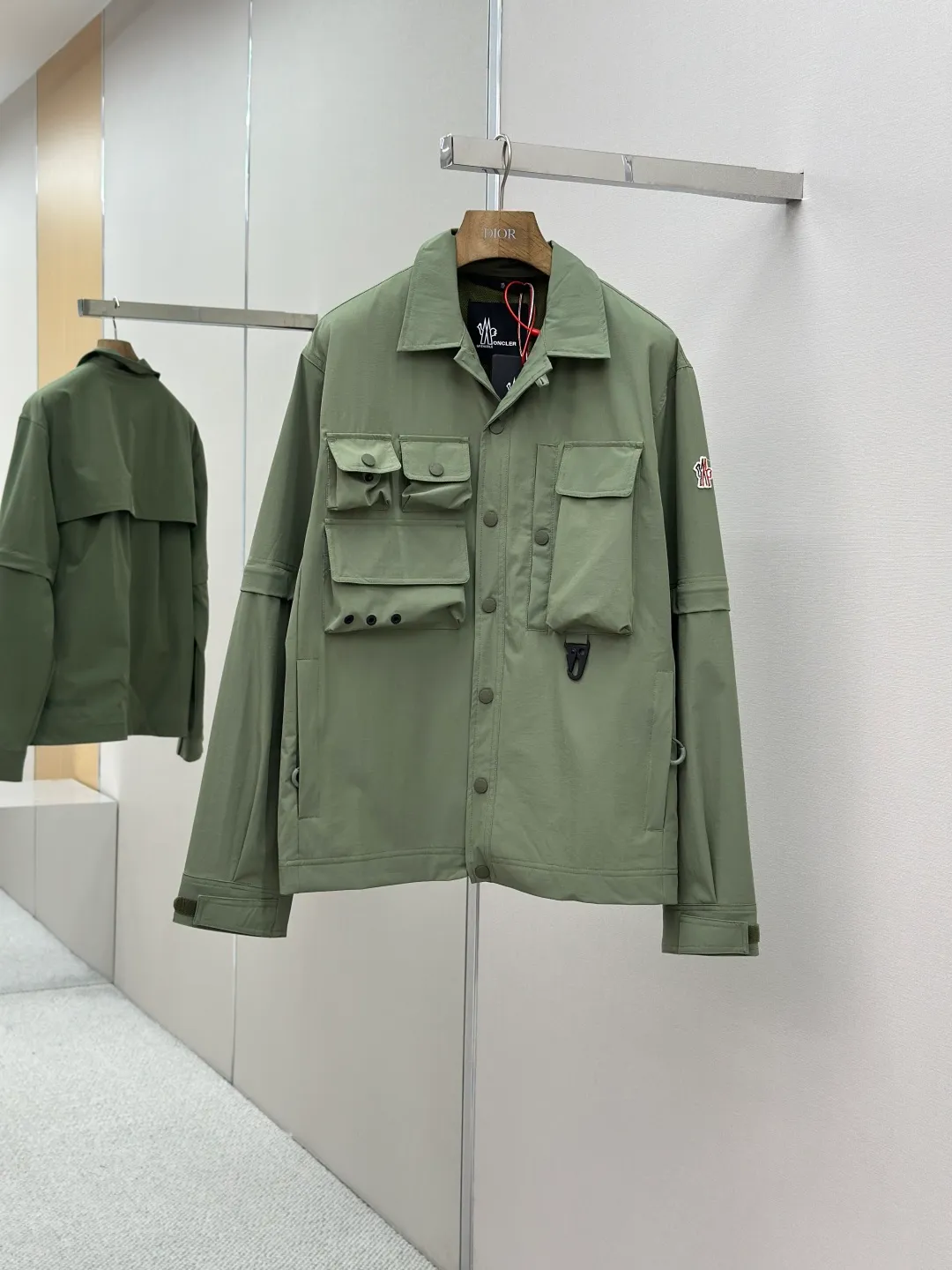 P640 Moncler Grenoble functional outdoor Custom dyed double stretch mercerized poplin Custom dyed soft mesh pongee Excellent texture Comfortable and close to the skin Dark green inspired by plant texture The color is taken from sage leaves soaked in morning dew Precision narrative of functional pocket system Balance of function and aesthetics The iconic Moncler logo appears on the sleeves, fully recognizable The triangular logo of the same color is hidden in the fabric texture like a mark in the undercurrent of the deep sea, extremely invisible and yet obvious The detachable sleeve design allows for diversified outfits. You can switch styles at will. It is chic and free. It shows nobility. It balances outdoor practicality and urban aesthetics and leads the fashion. Process 1: Using three-in-one process, the glue is firstly applied evenly on the surface of the substrate that needs to be composited, and then dried and solidified. Then the glue-coated substrate is composited with the non-woven fabric, and then cooled and solidified, and then composited with the filter non-woven fabric. The workmanship is cumbersome and complex, time-consuming and labor-intensive. Process 2: Embossing composite technology ensures that the embossed size and shape are consistent with the original through scanning, and then uses special glue as an adhesive to combine and then solidify to achieve complete dryness and optimal bonding effect. Process 3: Using CNC laser burning and cutting. Based on the high energy characteristics of the laser, the moving path of the laser beam is precisely controlled by the laser generator to achieve precise cutting of the shape of the piece. Process 4: Template machine bag opening. The preset template guides the position, shape and size of the bag opening. The accuracy ensures the quality of the bag opening effect. Process 5: Using infrared special machine buttoning, the position is more precise and strong. Accessories: Customized Moncler snap button Customized Moncler resin buckle Customized Moncler logo stamp Customized Moncler logo armband Customized Moncler zipper rope ring Customized Moncler zipper pull Customized Moncler trademark Version: Loose version Function: Detachable sleeve splicing Style can be switched at will Size: 1 2 3 4