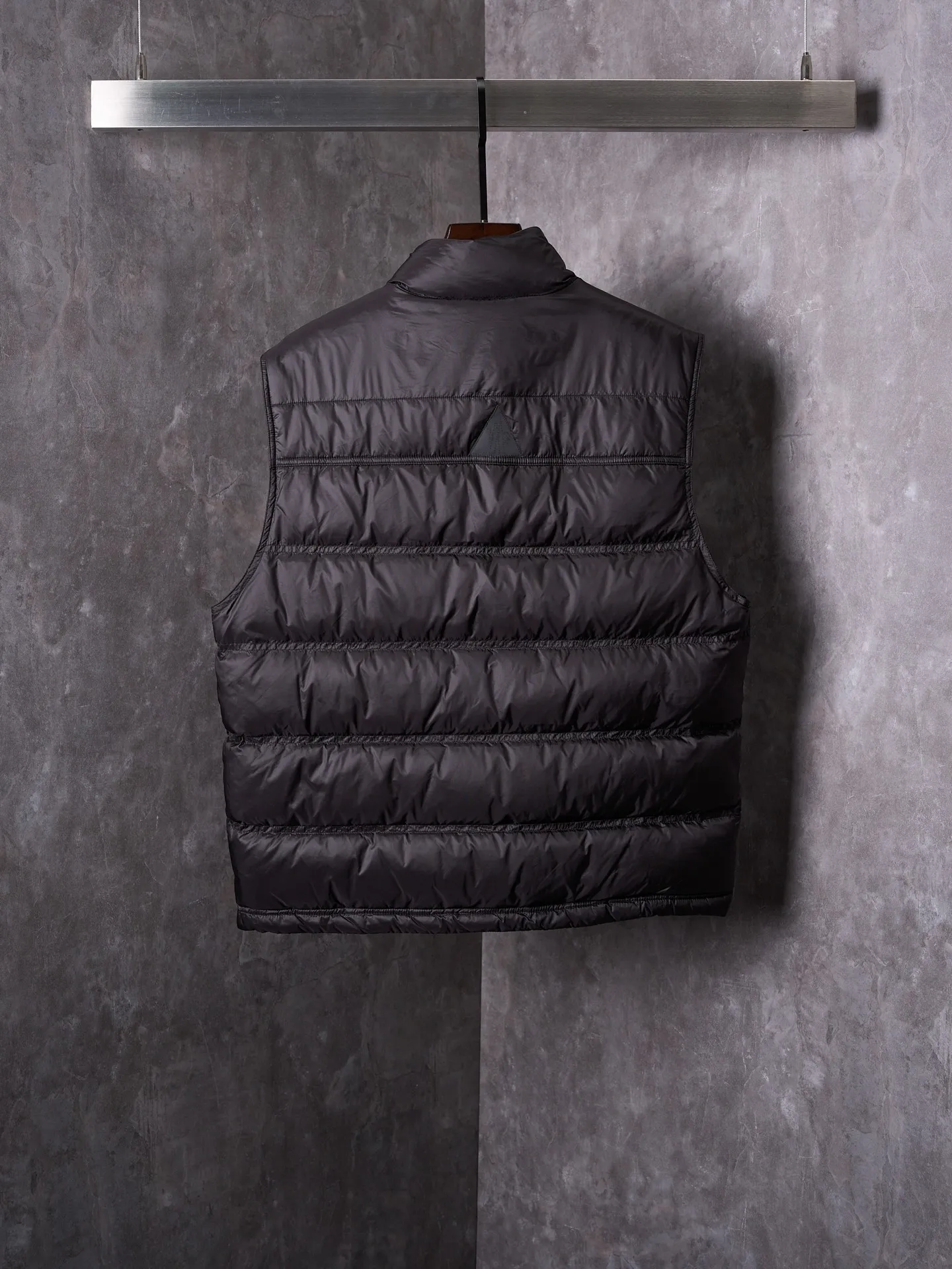 P680 Actual hanging auction] MONCLER/Mandow embroidered reflective logo stand-up collar down vest [Ready stock] 1 2 3 4 It is made of extremely fine nylon yarn and woven in a high-density way. The number of yarns per unit area is large, and the gaps between the yarns are very small, which can effectively block the penetration of cold wind. The fine weave keeps it lightweight and soft to the touch, physically restricting the lightweight down fibers from slipping through the gaps. Nylon fiber itself has good wear resistance and is not easy to snag, which significantly extends its service life and can easily cope with the needs of multiple scenarios.  The lining is made of high-density weaving of 100% polyester fiber, with a thickness of 0.08mm to avoid increasing the overall weight and making it smooth to wear. The high-density weaving structure forms a wind resistance layer to protect the thermal efficiency of the thermal layer from loss. It can withstand the expansion pressure of down and prevent deformation and damage after long-term use.  It uses 90 white duck down with a weight of 130g to ensure excellent thermal insulation performance. After strict screening and processing, the velvet is not easy to get drilled, ensuring durability.  Through the reflective cloth punching process, the logo is regularly arranged on the triangular reflective mark with dozens of small holes, which not only improves functionality but also enhances recognition and aesthetics.