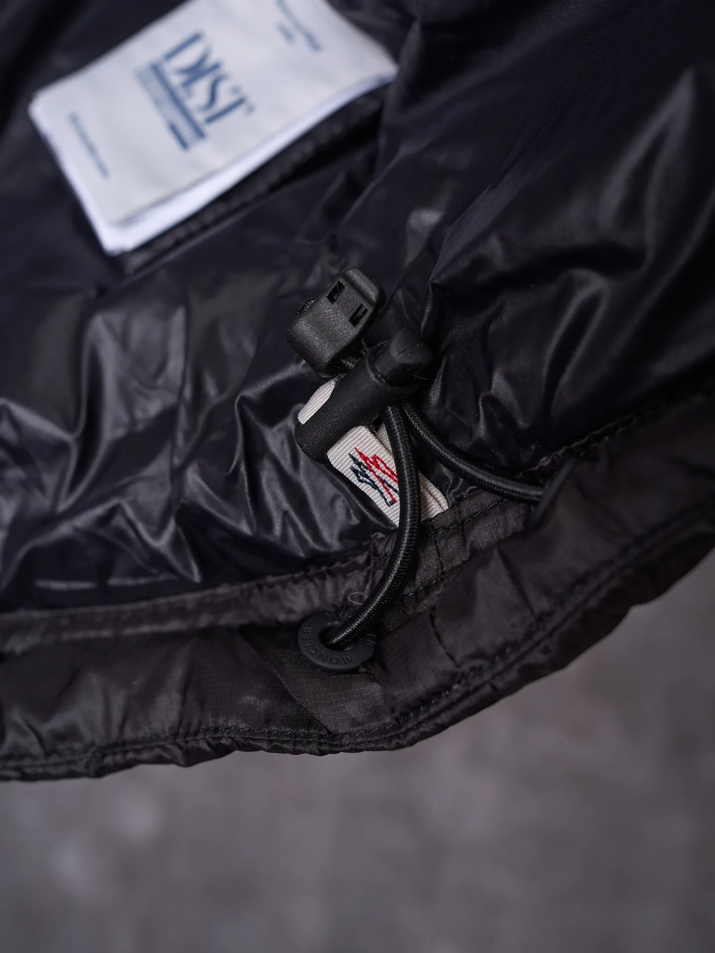 P680 Actual hanging auction] MONCLER/Mandow embroidered reflective logo stand-up collar down vest [Ready stock] 1 2 3 4 It is made of extremely fine nylon yarn and woven in a high-density way. The number of yarns per unit area is large, and the gaps between the yarns are very small, which can effectively block the penetration of cold wind. The fine weave keeps it lightweight and soft to the touch, physically restricting the lightweight down fibers from slipping through the gaps. Nylon fiber itself has good wear resistance and is not easy to snag, which significantly extends its service life and can easily cope with the needs of multiple scenarios.  The lining is made of high-density weaving of 100% polyester fiber, with a thickness of 0.08mm to avoid increasing the overall weight and making it smooth to wear. The high-density weaving structure forms a wind resistance layer to protect the thermal efficiency of the thermal layer from loss. It can withstand the expansion pressure of down and prevent deformation and damage after long-term use.  It uses 90 white duck down with a weight of 130g to ensure excellent thermal insulation performance. After strict screening and processing, the velvet is not easy to get drilled, ensuring durability.  Through the reflective cloth punching process, the logo is regularly arranged on the triangular reflective mark with dozens of small holes, which not only improves functionality but also enhances recognition and aesthetics.