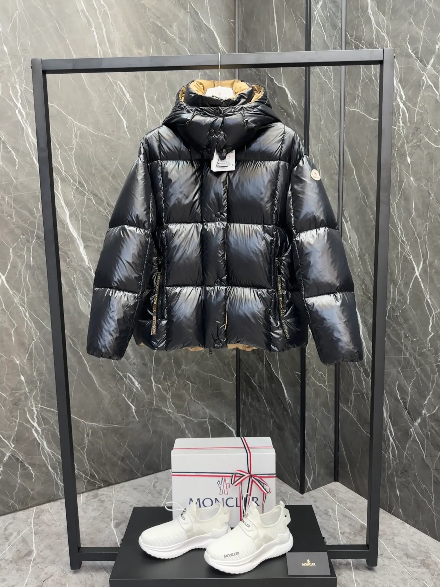 P720 Premium Down ⬆️ The Moncler Parana down jacket stands out with its shiny patented nylon fabric, featuring contrasting interior and exterior tones. The short design, the hood is detachable when the weather warms up, and the large drawstring draw inspiration from trendy brand logo fashion, embellished with Moncler letters.  •Made of patented nylon •Patented nylon lining •95 EU goose down filling •Removable hood •Contrast color lining •Zip and snap fastening •Zip pockets •Felt logo Size:0-3 Women's D9880046730