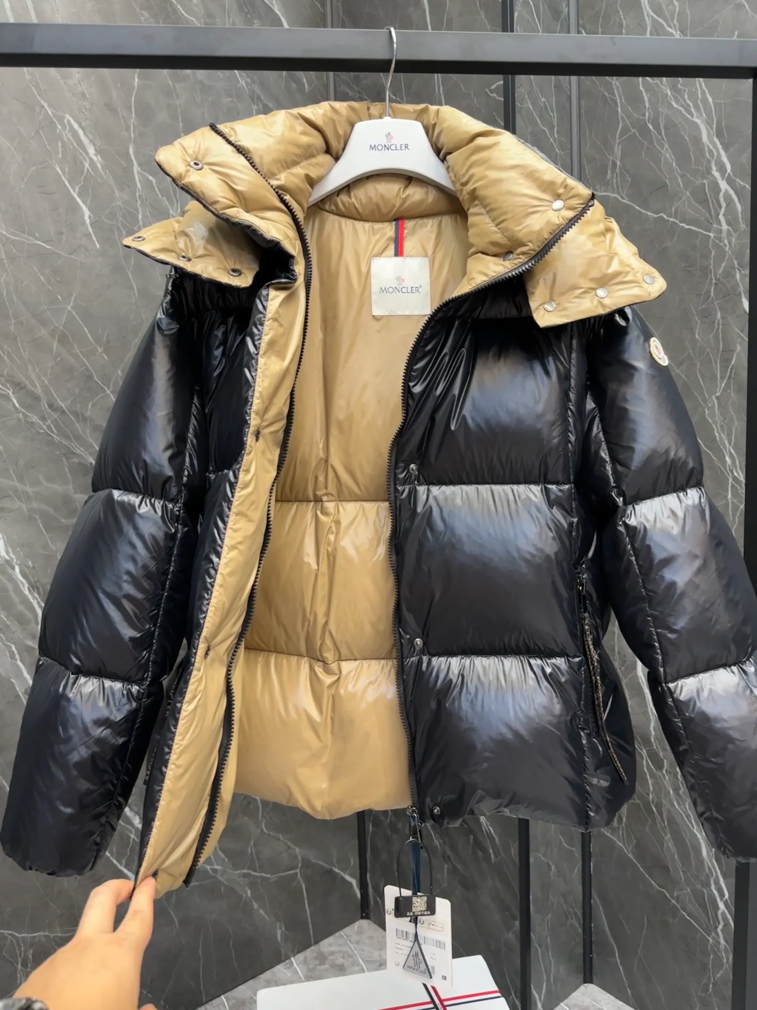 P720 Premium Down ⬆️ The Moncler Parana down jacket stands out with its shiny patented nylon fabric, featuring contrasting interior and exterior tones. The short design, the hood is detachable when the weather warms up, and the large drawstring draw inspiration from trendy brand logo fashion, embellished with Moncler letters.  •Made of patented nylon •Patented nylon lining •95 EU goose down filling •Removable hood •Contrast color lining •Zip and snap fastening •Zip pockets •Felt logo Size:0-3 Women's D9880046730
