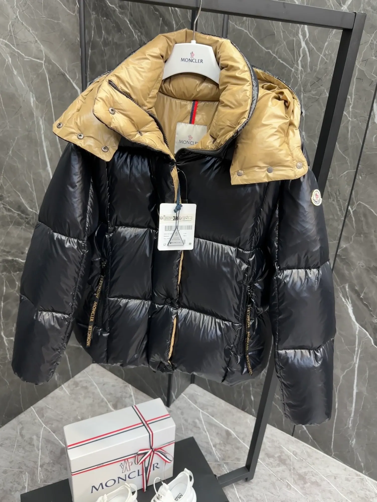 P720 Premium Down ⬆️ The Moncler Parana down jacket stands out with its shiny patented nylon fabric, featuring contrasting interior and exterior tones. The short design, the hood is detachable when the weather warms up, and the large drawstring draw inspiration from trendy brand logo fashion, embellished with Moncler letters.  •Made of patented nylon •Patented nylon lining •95 EU goose down filling •Removable hood •Contrast color lining •Zip and snap fastening •Zip pockets •Felt logo Size:0-3 Women's D9880046730