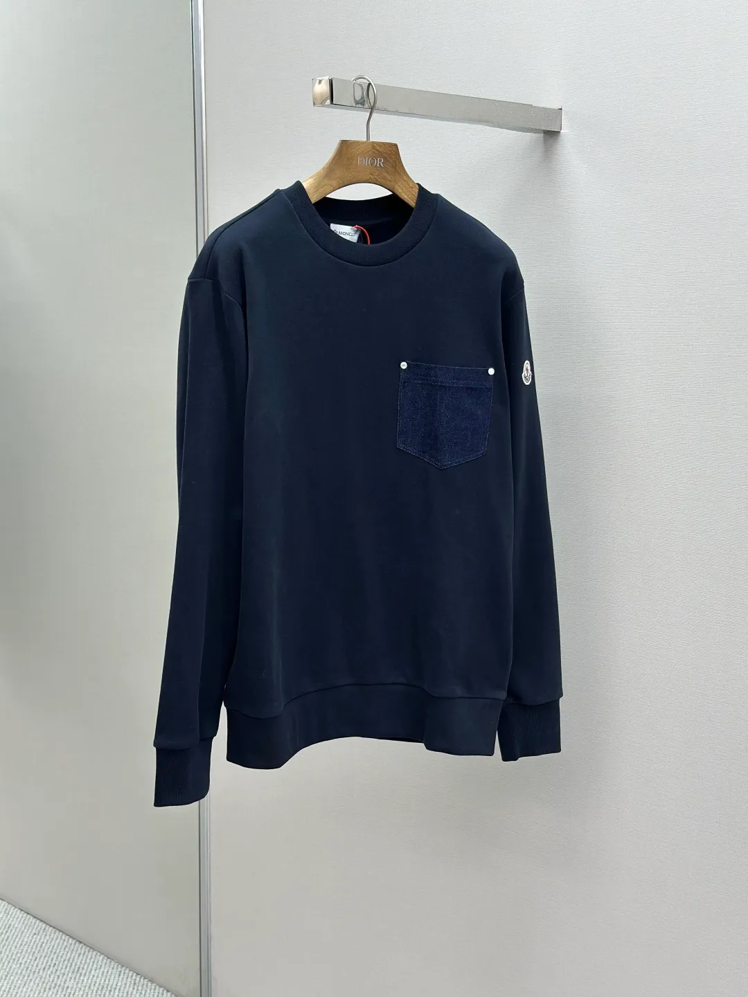 P320 Moncler denim pocket sweatshirt. Customized cotton soft velvet and cloud yarn water-brushed denim. Excellent texture, comfortable and close to the skin. The rich navy blue is the main color, showing an elegant gentleman's style. The unique denim chest pocket on the chest adds a touch of uninhibited casualness with the unique ruggedness and retro of denim. The iconic Moncler embroidered logo appears on the sleeves. It is highly recognizable and exudes a sense of luxury from the inside out. Find the perfect balance between simplicity and sophistication. Process 1: Hidden seamless hemming. Use precise laser cutting to cut the edges of the pocket into the required denim shape to ensure neat and precise edges. Then use one-piece molding technology to perfectly combine the denim material with the pocket to achieve a seamless connection. Process 2: Manual nailing using a servo motor-driven nailing device to accurately drive the bottom nails into the splicing of denim and sweatshirt velvet. Precise positioning to keep the edges of the pockets flat. Process 3: The fabrics have been washed, giving a better hand feel and not easy to deform. Not easy to shrink, not easy to fade, maintain long-term beauty Accessories: Customized Moncler embroidered logo Customized Moncler bottom nails Customized Moncler trademark Version: Loose version Size: S M L XL Style number: 25338-A75
